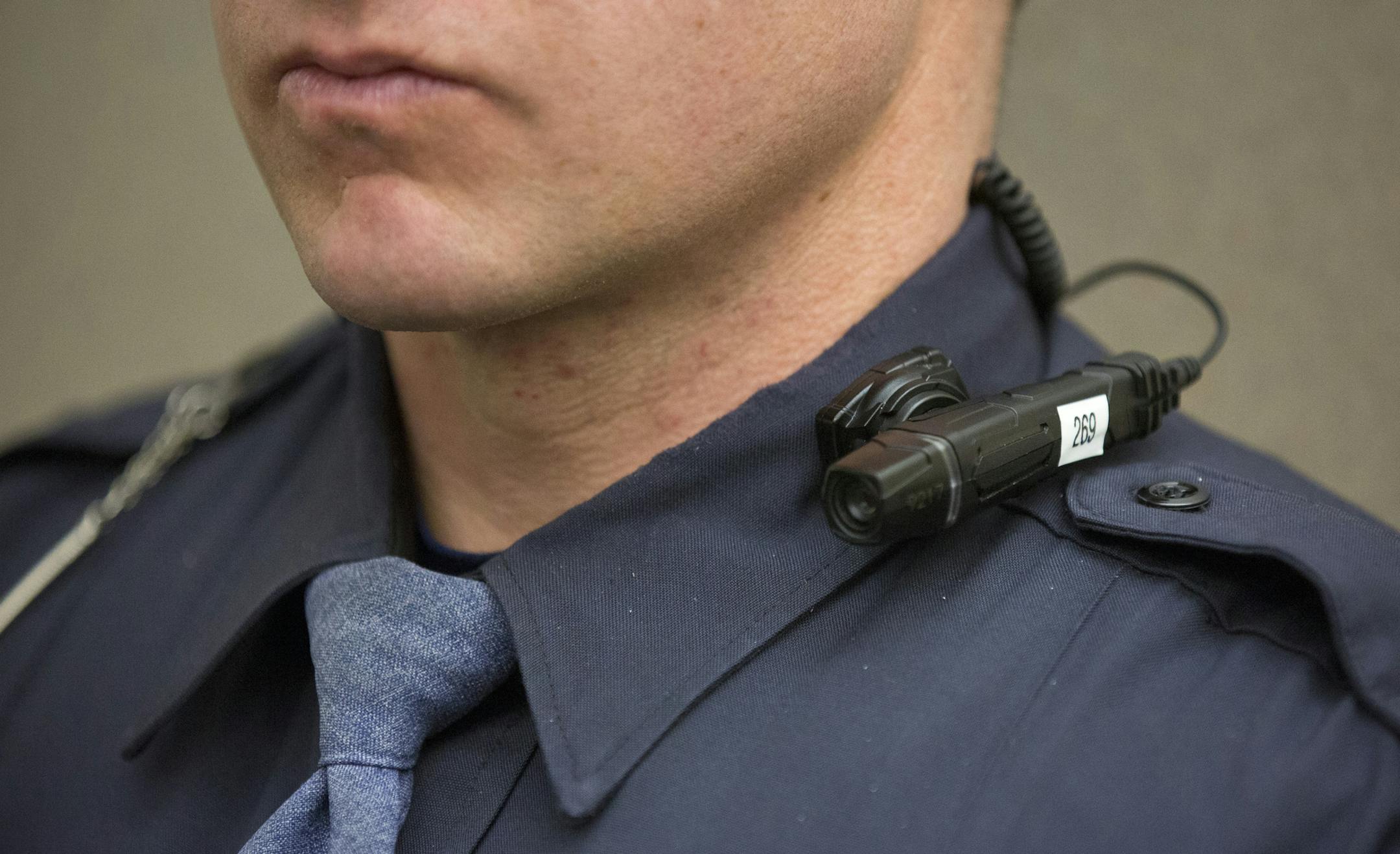 In a Friday, March 6, 2015 photo, a body cam with flexible mounting options for multiple officers at one scene is shown by a Grand Rapids police officer during a media event at the Grand Rapids Police Department Headquarters in Grand Rapids, Mich. Grand Rapids City Commission on Tuesday, March 10, authorized spending $674,124 from a special tax fund to pay startup costs for 200 body cams. (AP Photo/The Grand Rapids Press, Hugh Carey) ALL LOCAL TELEVISION OUT; LOCAL TELEVISION INTERNET OUT ORG XM