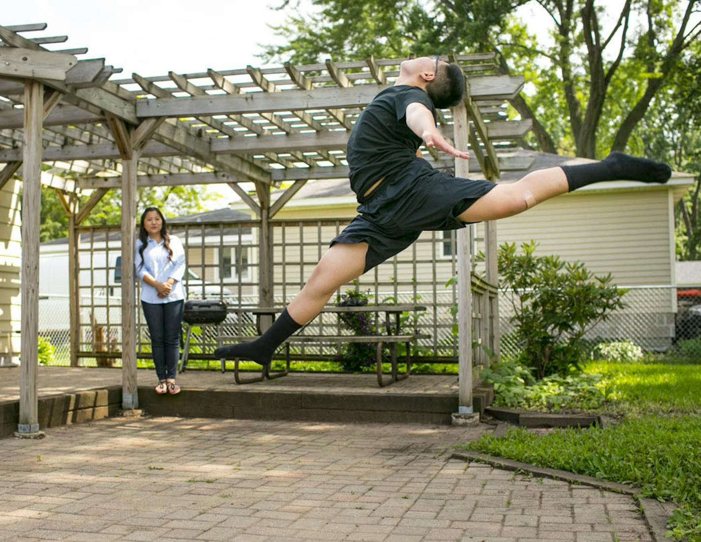 Dmitri Moua practices in his back yard while his mom Boa watches. loves to dance and is on his school's dance team in Minnesota. Moua isn't allowed to dance competitvely in Minnesota because of his gender.