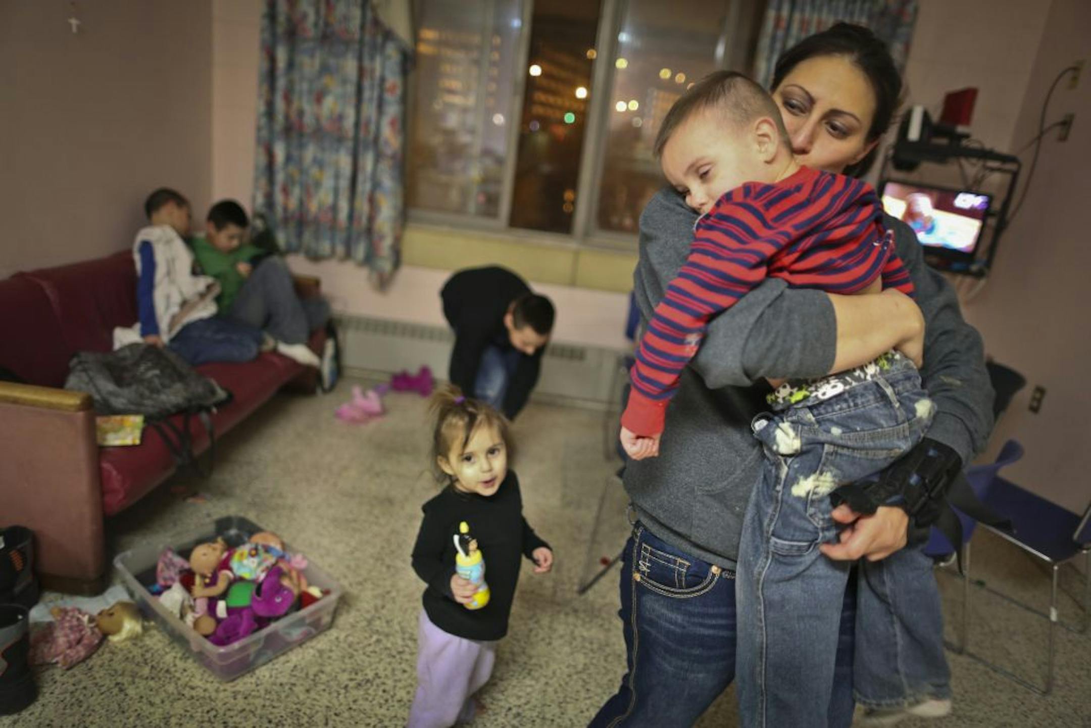 Elena Menz, 29, comforting 4-year-old son Ethan, and her five children live at a shelter in Minneapolis. "It's a roof over our head and it's home for us," she said.