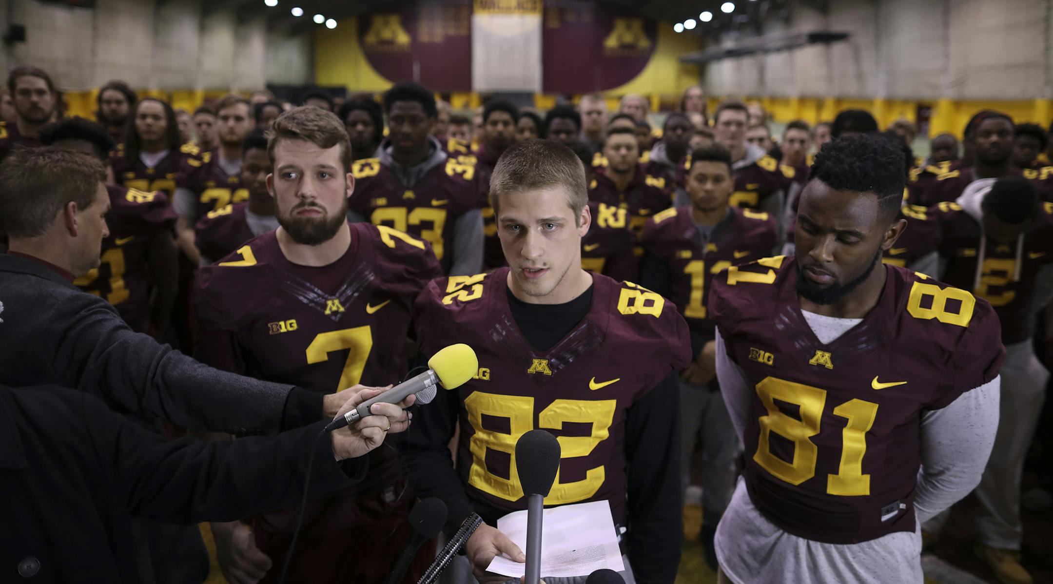 Wide receiver Drew Wolitarsky, center, flanked by quarterback Mitch Leidner, left, and tight end Duke Anyanwu, and with the rest of the team standing behind them, read a statement on Dec. 15 on behalf of the players in the Nagurski Football Complex.