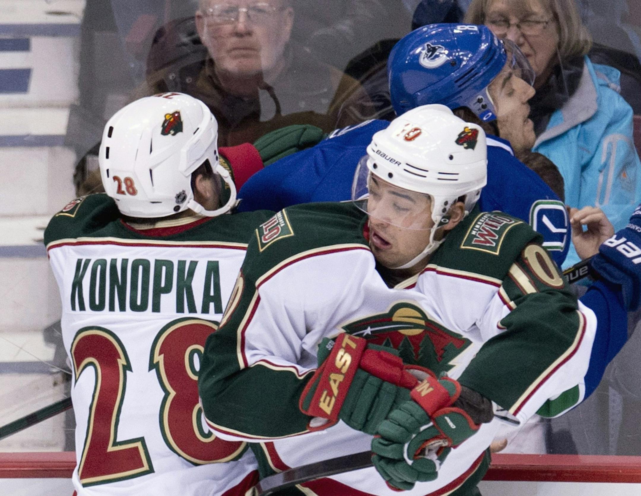 The Wild's Zenon Konopka (28) and Devin Setoguchi (10) pinned Vancouver's Chris Tanev (8) into the boards.