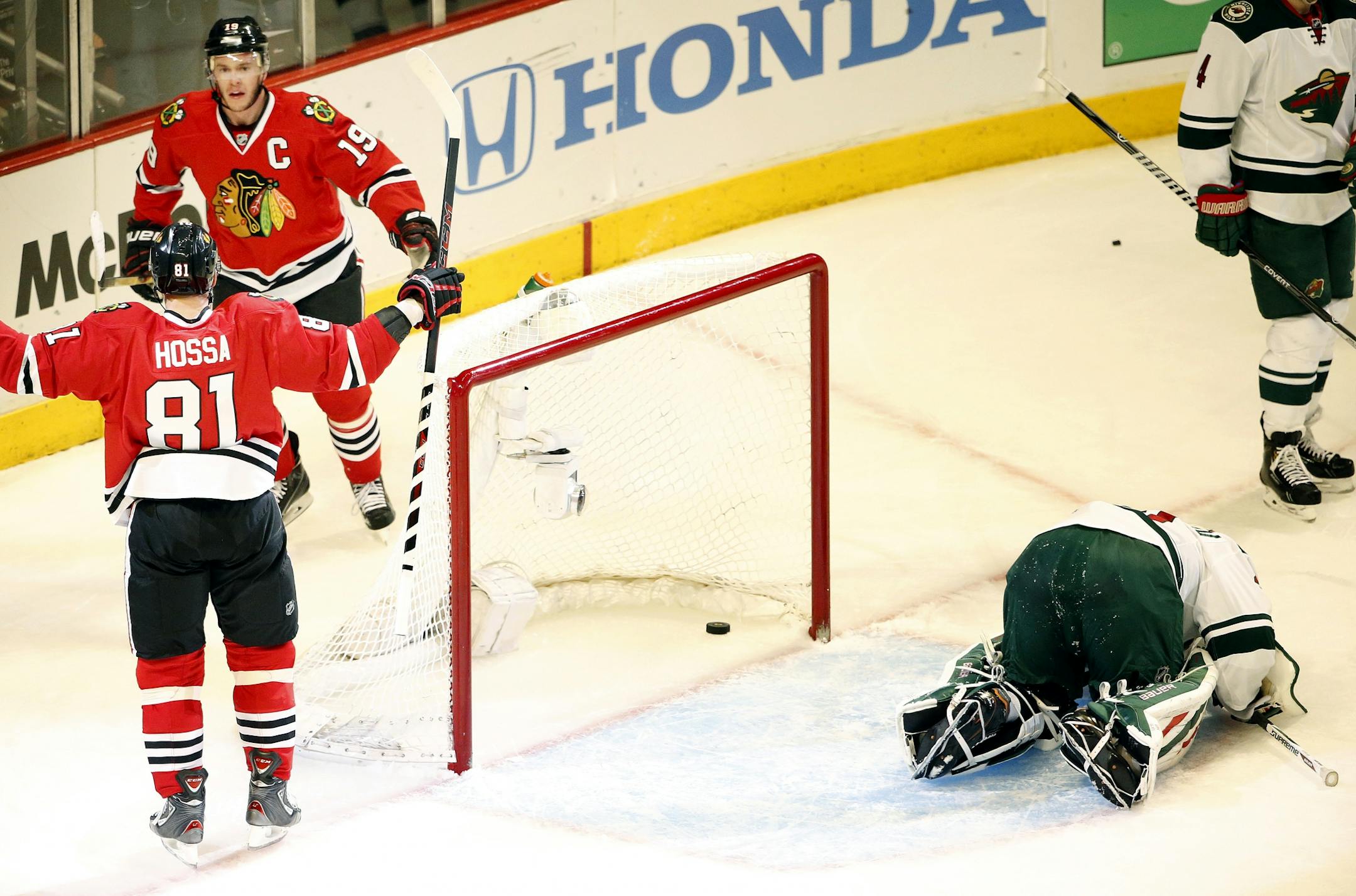 Jonathan Toews (19) and Marian Hossa (81) celebrated after Toews scored on Wild goalie Ilya Bryzgalov (30) in the first period.