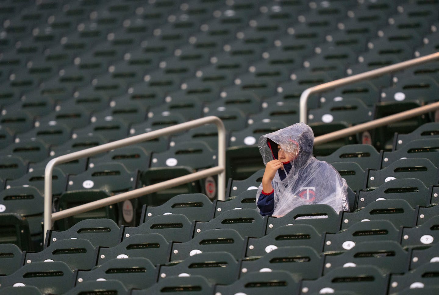 A Minnesota Twins fan sits in the stands during a rain delay for their game against the Cleveland Guardians Friday, September 9, 2022 at Target Field in Minneapolis. ]