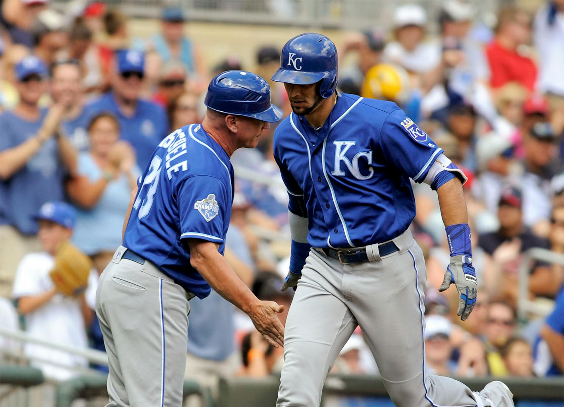 Kansas City Royals' Paulo Orlando, right, is congratulated by third base coach Mike Jirschele while rounding third base after hitting a three-run home run off Minnesota Twins pitcher Hector Santiago during the fourth inning of a baseball game, Sunday, Aug. 14, 2016, in Minneapolis.