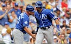 Kansas City Royals' Paulo Orlando, right, is congratulated by third base coach Mike Jirschele while rounding third base after hitting a three-run home