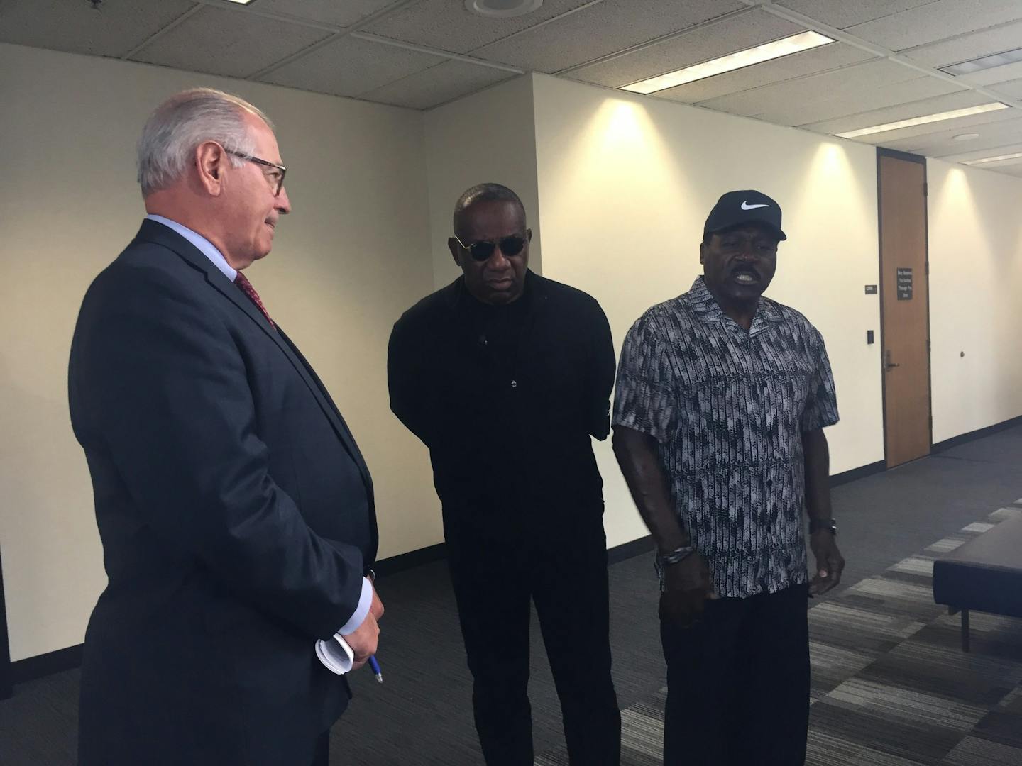 Activist Spike Moss (right), accompanied by activist Tyrone Terrill, confronts Hennepin County Attorney Mike Freeman after a news conference about the charges.