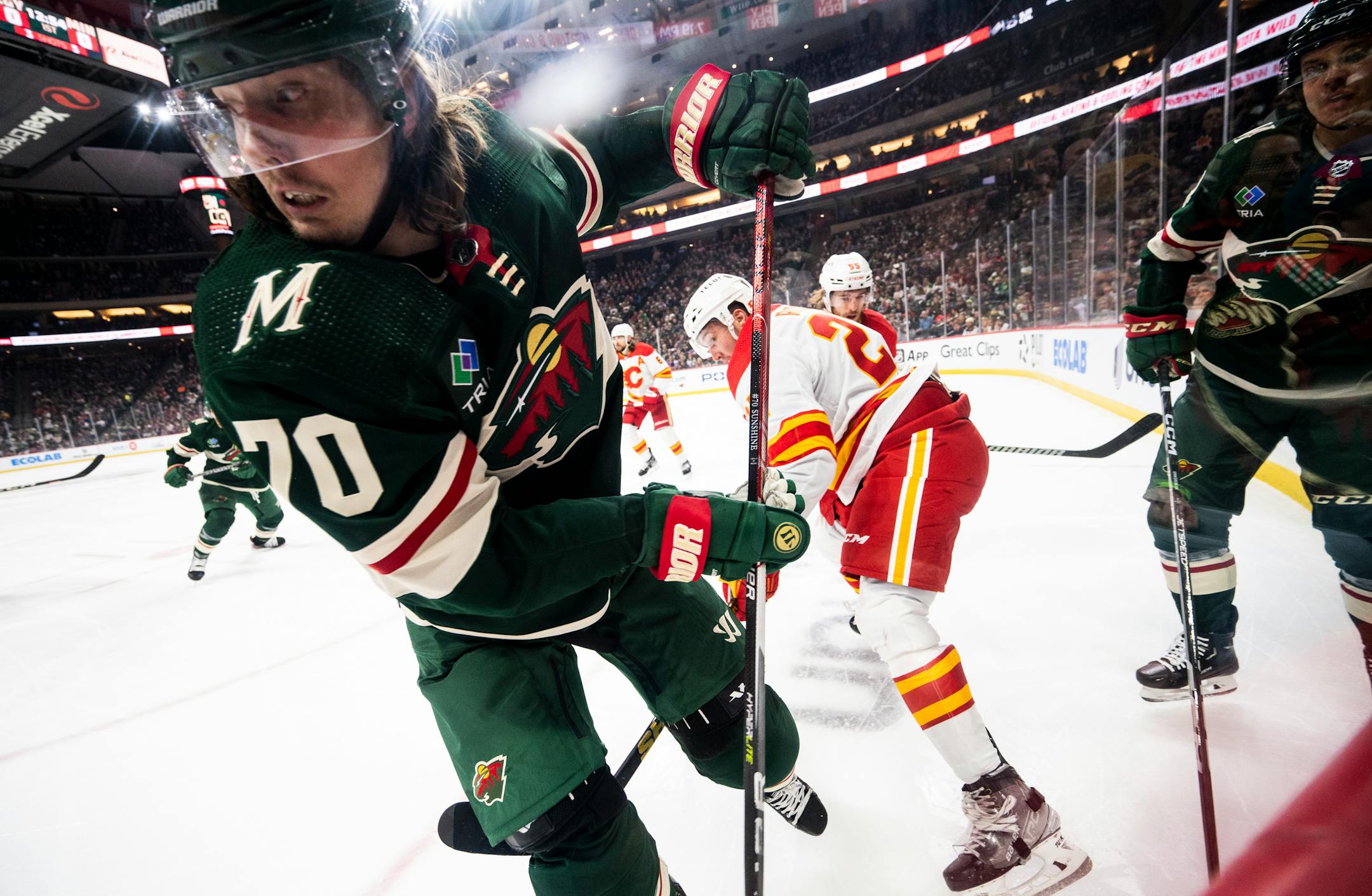Minnesota Wild center Oskar Sundqvist (70) battles for the puck in the corner against the Calgary Flames during the first period.