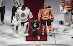 Minnesota Wild's Matt Dumba takes a knee during the national anthem flanked by Edmonton Oilers' Darnell Nurse, right, and Chicago Blackhawks' Malcolm 