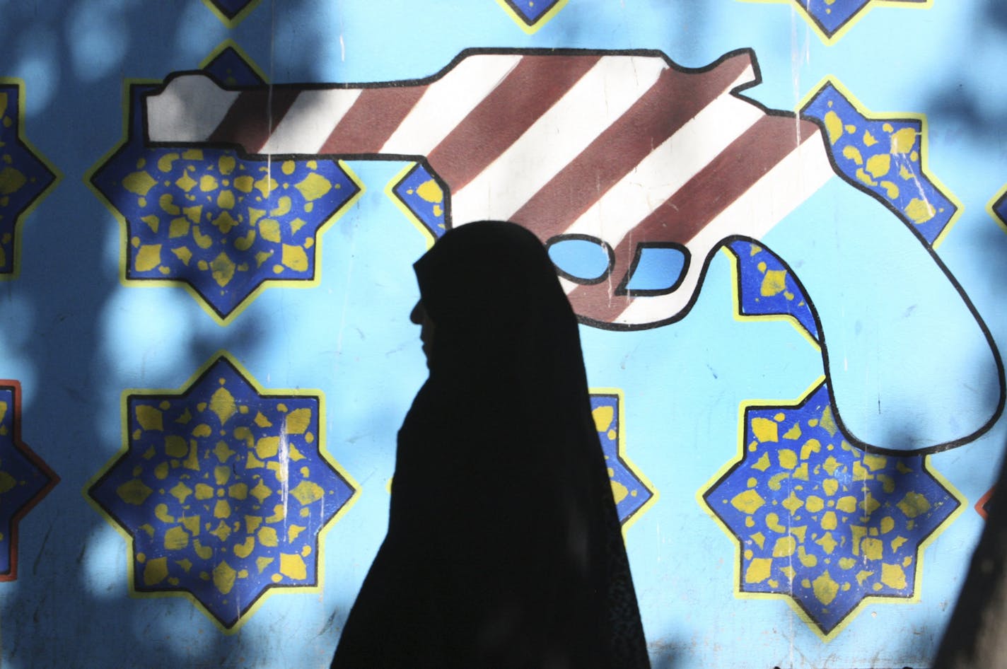 An Iranian woman walks past an anti-US mural, painted on the wall of the former US Embassy in Tehran, Iran, at the side lines of an annual state-backed rally, on Friday, Nov. 4, 2011, marking the anniversary of the seizure of the US Embassy by militant students on Nov. 4, 1979, when militant Iranian students who believed the embassy was a center of plots against the Persian country held 52 Americans hostage for 444 days. The US severed diplomatic ties in response, and the two countries have not