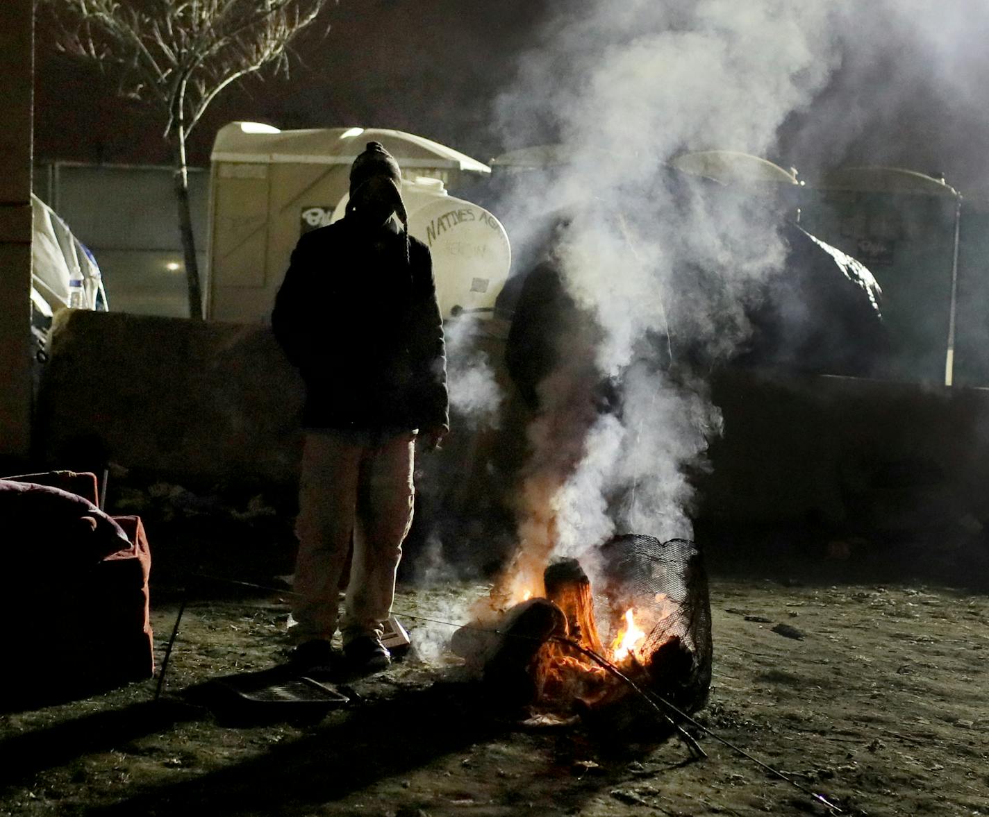 People at the Minneapolis homeless encampment tried to stay warm near an early morning fire.