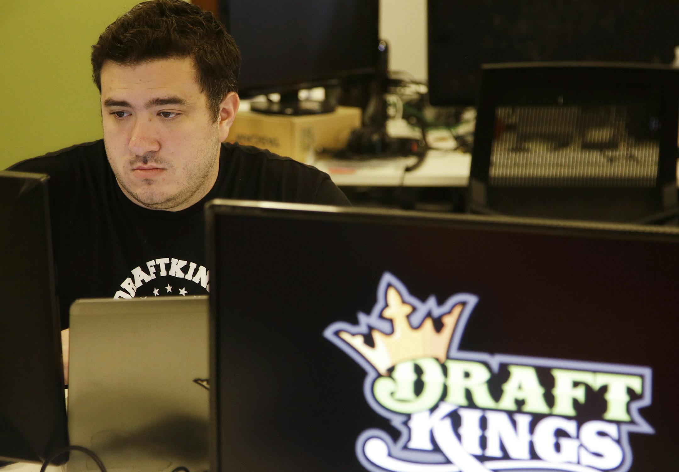 In this Sept. 9, 2015 photo Len Don Diego, marketing manager for content at DraftKings, a daily fantasy sports company, works at his station at the company's offices in Boston. (AP Photo/Stephan Savoia)