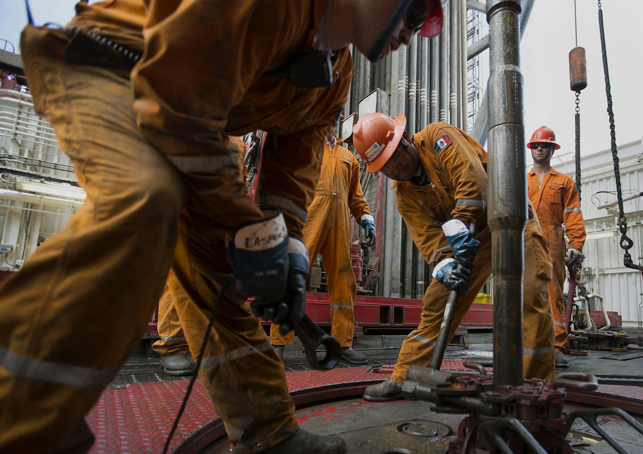 FILE PHOTO: Workers prepare drilling pipe on the Petroleos Mexicanos (Pemex) La Muralla IV deep sea crude oil platform in the waters off Veracruz, Mexico, on Friday, Aug. 30, 2013. Oil extended losses below $60 a barrel amid speculation that OPEC's biggest members will defend market share against U.S. shale producers. Photographer: Susana Gonzalez/Bloomberg ORG XMIT: 528373363
