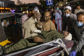 A person wounded in a bomb blast outside the Kabul airport in Afghanistan on Thursday, Aug. 26, 2021, arrives at a hospital in Kabul. The Pentagon con