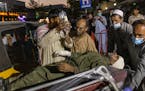 A person wounded in a bomb blast outside the Kabul airport in Afghanistan on Thursday, Aug. 26, 2021, arrives at a hospital in Kabul. The Pentagon con