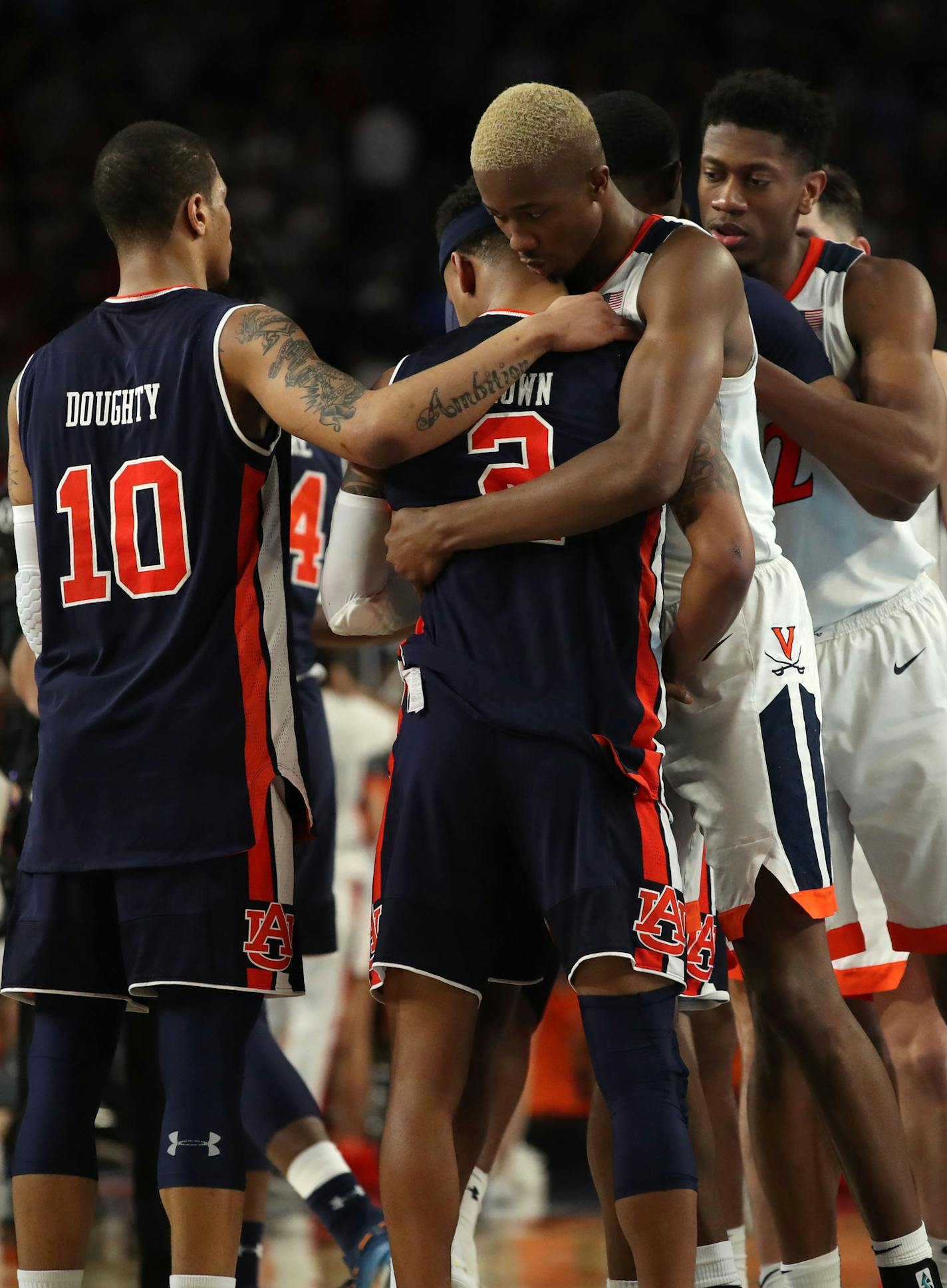 Auburn guard Bryce Brown (2) is embraced by Virginia Cavaliers forward Mamadi Diakite (25) near Auburn guard Samir Doughty (10) after Virginia won the game. ] CARLOS GONZALEZ &#xa5; carlos.gonzalez@startribune.com Auburn played Virginia in a semifinal of the NCAA Division I Men's Basketball Championship Final Four on Saturday, April 6, 2019 at U.S. Bank Stadium in Minneapolis. Virginia won, 63-62.