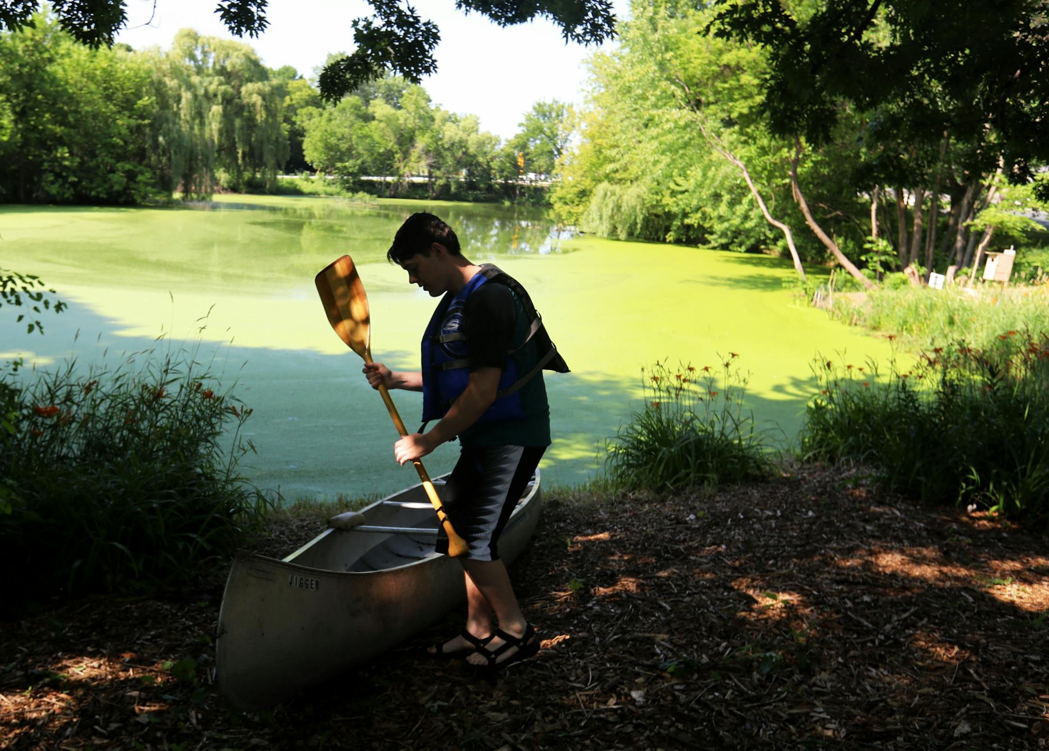 Bloomington resident Nick Niziolek, 17, prepared to canoe near a "floating island," in Winchester Pond, steps from his family's residence. The Niziolek family and neighbors undertook the task to clean up the pond and surrounding land and was seen Wednesday, July 23, 2019, in Bloomington, MN.