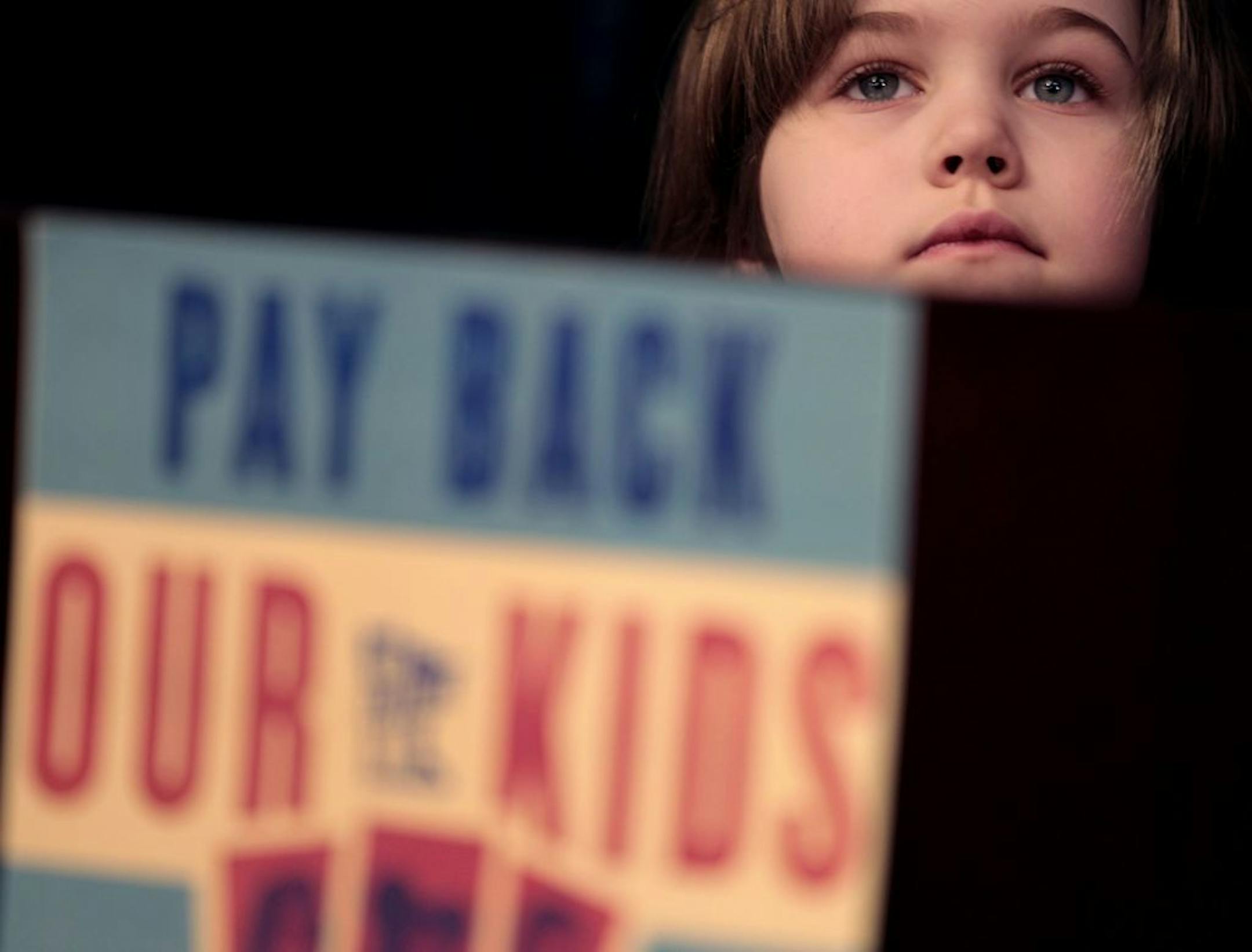 Linnea Dial, 5 stood near the podium as her dad Bill Dial spoke during a press conference held Monday February 27, 2012 at the capitol in St. Paul, MN, parents and students joined legislators at the Capitol to support a new bill that would pay back the $2.2. billon owed to Minnesota public schools by closing corporate tax loopholes.