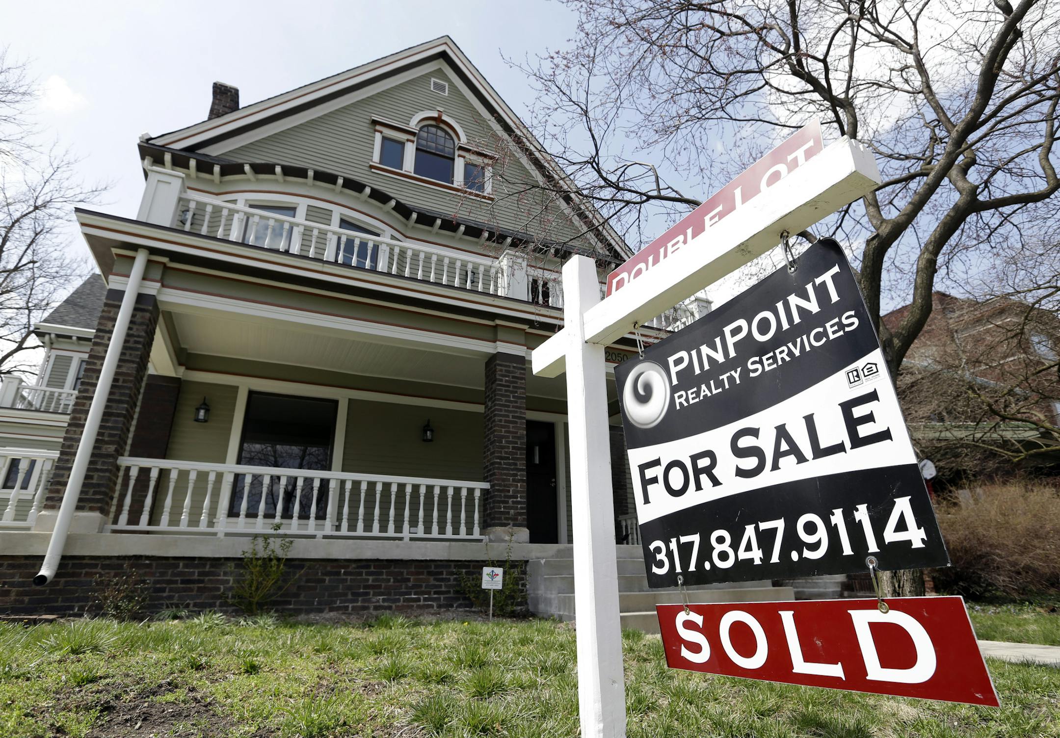 A "Sold" sign is posted outside a home in Indianapolis, Tuesday, April 9, 2013. Real estate agents say pent-up demand and low interest rates are leading to a resurgence in the housing market, with home sales up 20.5 percent statewide through the first two years of the month. (AP Photo/Michael Conroy) ORG XMIT: MIN2013052218390414