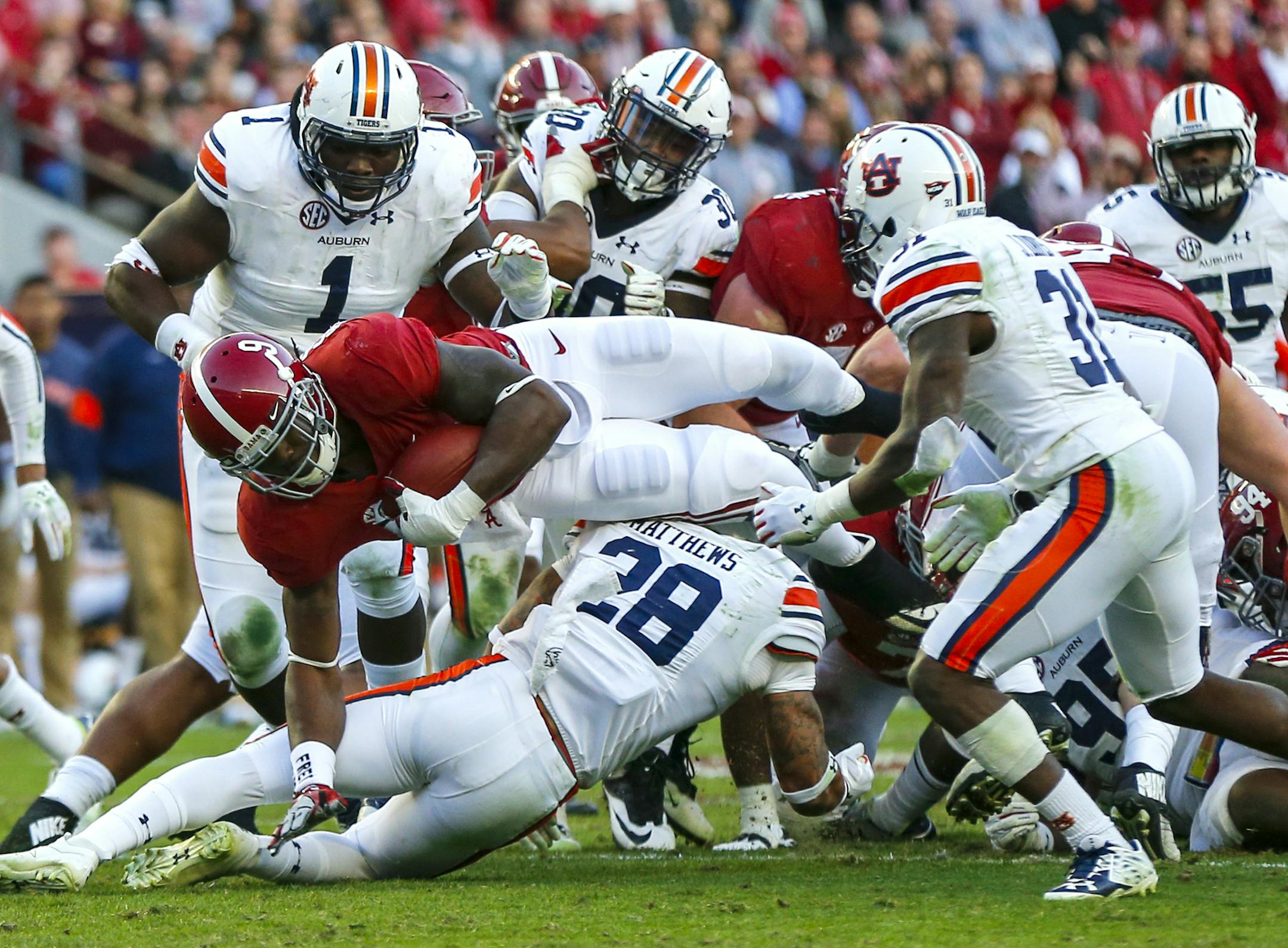 Alabama running back Bo Scarbrough (9) dives over for a first down during the first half of the Iron Bowl NCAA college football game against Auburn, Saturday, Nov. 26, 2016, in Tuscaloosa, Ala. (AP Photo/Butch Dill)