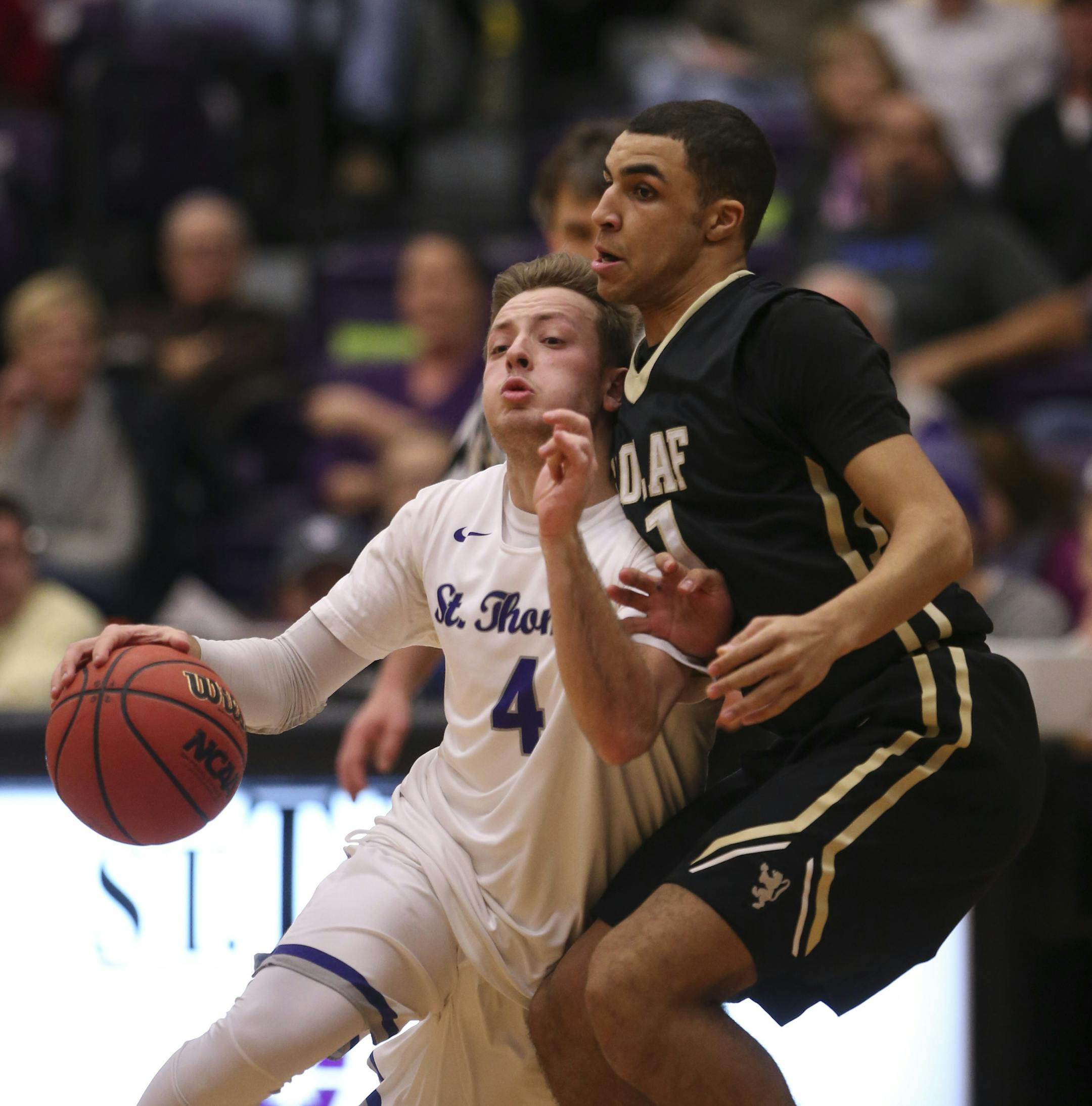 The Tommies' Grant Shaeffer drove around the Oles' Riley Parham in the second half Wednesday night. ] JEFF WHEELER ï jeff.wheeler@startribune.com Grant Shaeffer was two-time state champion at quarterback for Eden Prairie. Now he is a junior point guard for the University of St. Thomas basketball team. The Tommies beat St. Olaf 75-66 at Schoenecker Arena on the University of St. Thomas campus Wednesday night, January 20, 2016 in St. Paul.