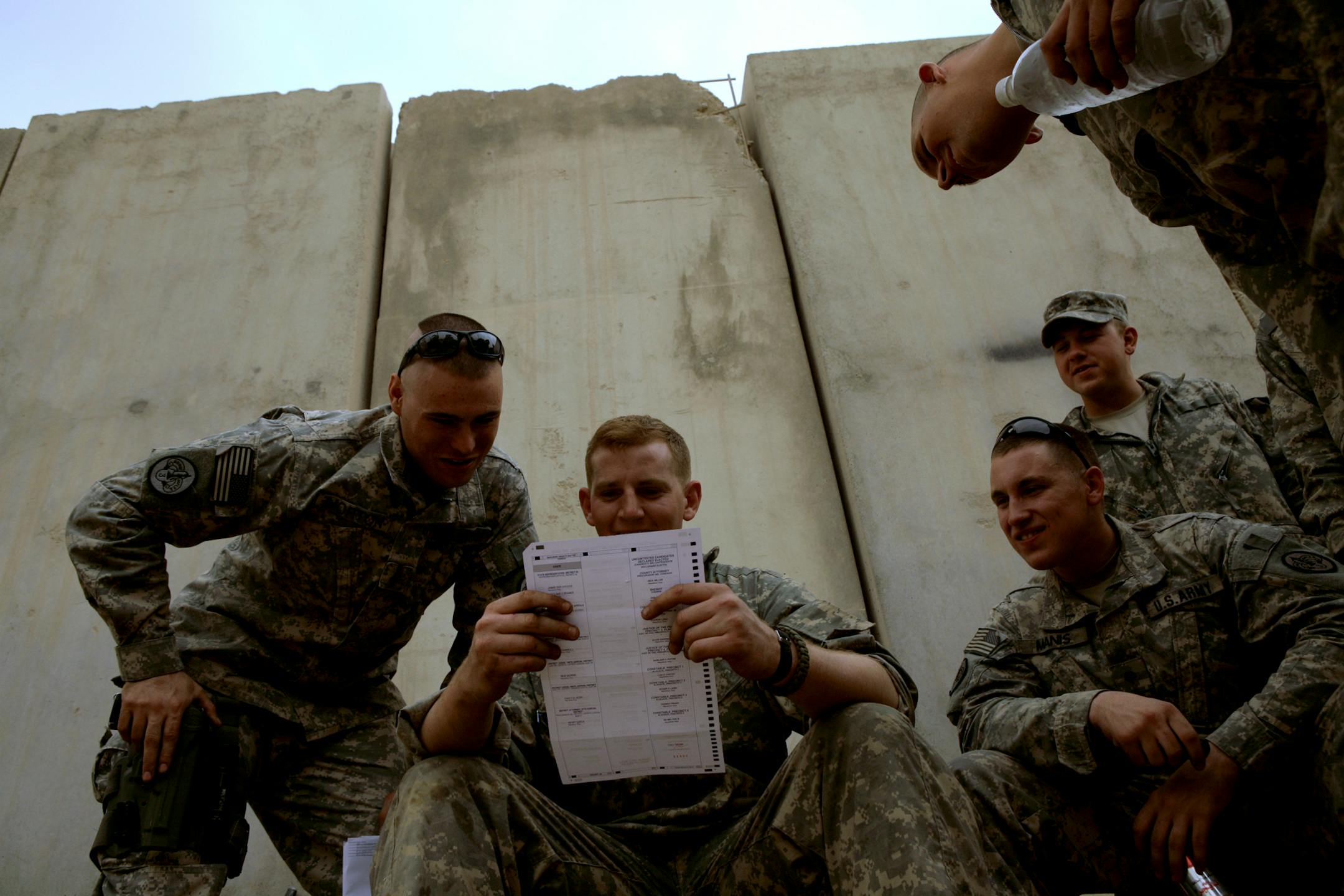 U.S. Army Cpl. Sean Morton, 25, from Boston, Mass., left, and a comrade assigned to Killer Troop, 3rd Squadron, 3rd Armored Cavalry Regiment, confer as they cast their votes for president at Forward Operating Base Marez in Mosul, Iraq, Wednesday, Oct. 22, 2008.