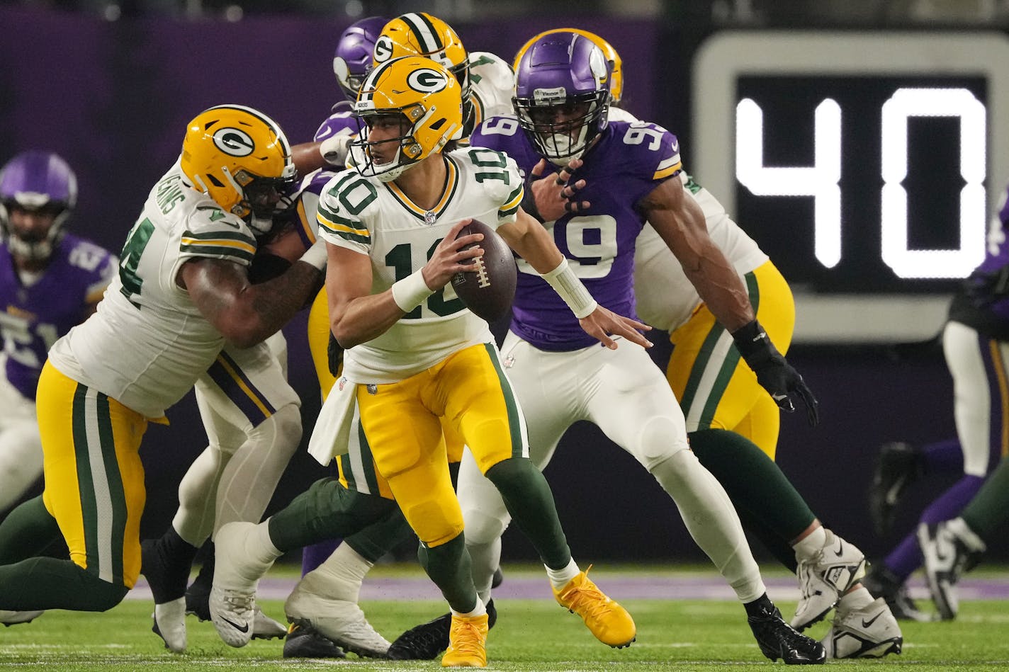 Green Bay Packers quarterback Jordan Love (10) scrambles out of the pocket under pressure from Minnesota Vikings linebacker Danielle Hunter (99) in the first quarter of an NFL game between the Minnesota Vikings and the Green Bay Packers Sunday, Dec. 31, 2023 at U.S. Bank Stadium in Minneapolis. ] ANTHONY SOUFFLE • anthony.souffle@startribune.com