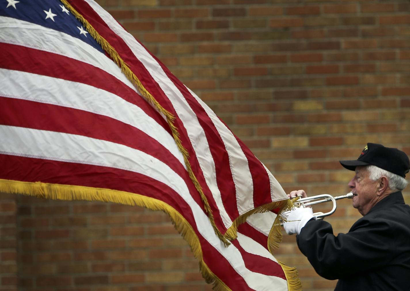 A gentle wind lifts the American flag as Vietnam Veterans of America Post 470 Honor Guards bugler Harold Reiner played Taps at funeral services for U.S. Marine veteran Gary S. Pearson Thursday, Oct. 24, 2013, at Calvary Lutheran Church in Golden Valley, MN. Reiner, 85, and a World War II Navy vet, on what the honor guards bring to the funeral for the deceased veteran: &#x201a;&#xc4;&#xfa;When its cold and your lips are against the mouthpiece, you ask yourself, &#x201a;&#xc4;&#xf2;Why am I doing