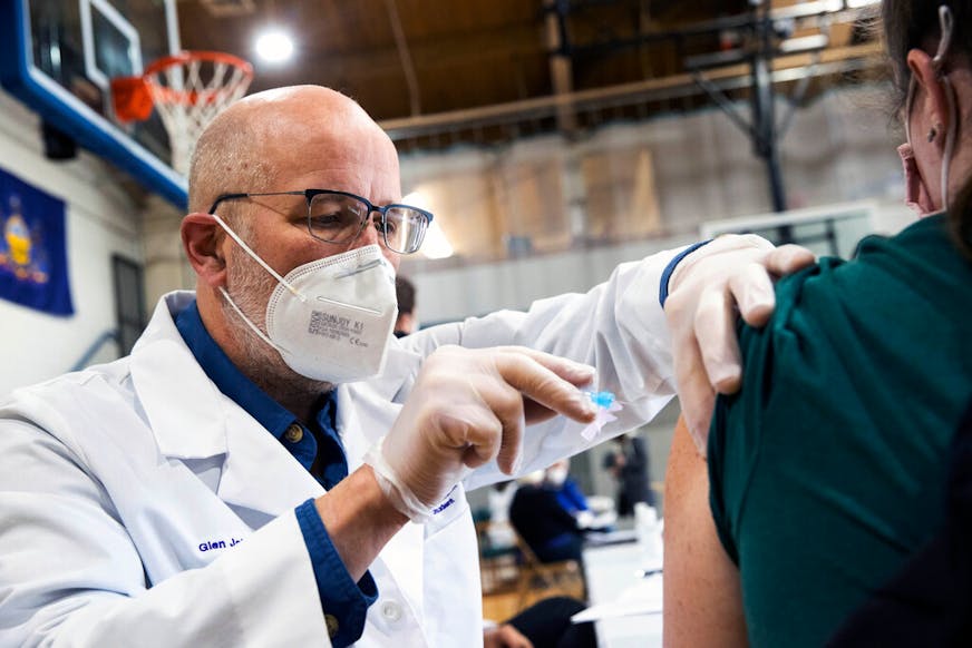 University of Scranton nursing student Glen Johnson administers the Moderna COVID-19 vaccine to a medical professional during a clinic at the Throop Civic Center in Throop, Pa. on Saturday, Jan. 9, 2021. The Lackawanna County Medical Society had about 400 doses of the Moderna vaccine on hand to administer to people in Pennsylvania's Phase 1A group of the vaccine rollout plan, which is limited to healthcare personnel and long-term care facility residents. (Christopher Dolan/The Times-Tribune via AP)