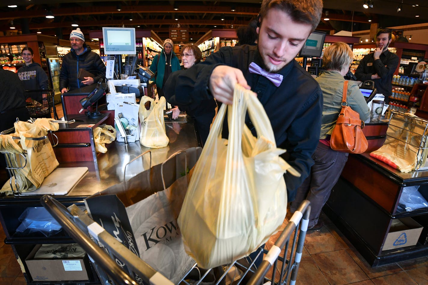 Alec Voight bagged groceries at Kowalski's in Minneapolis. A City Council member has reintroduced a proposal to charge five cents for each bag — paper, plastic and reusable — given by retailers.