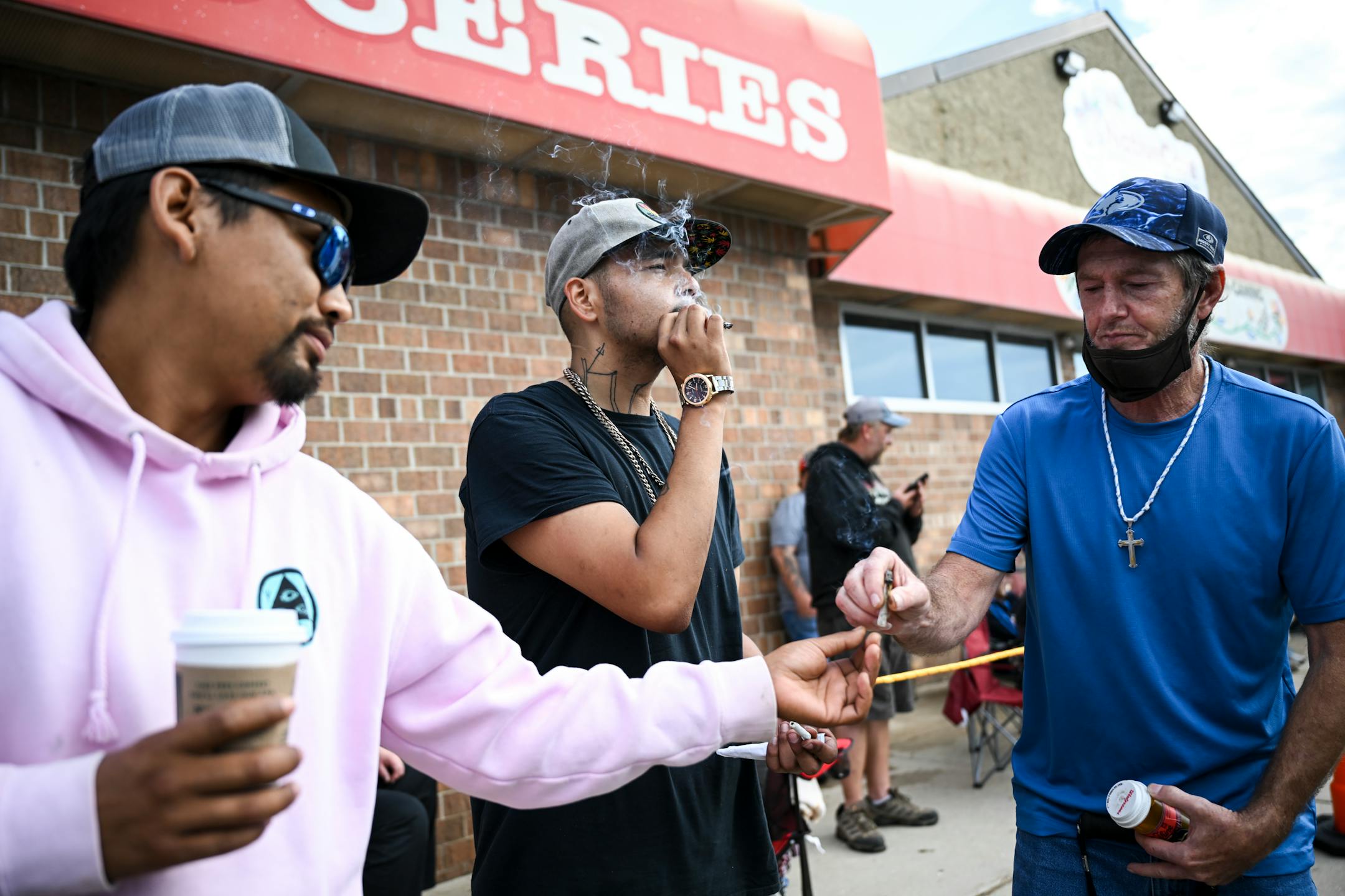 From left, John Wyllie, of Bemidji, Eugene Sayers, of Red Lake and Bill Skinner, of Ferguson, share a joint and a blunt before the state's first recreational cannabis dispensary opened Tuesday, Aug. 1, 2023 at NativeCare in Red Lake, Minn.
