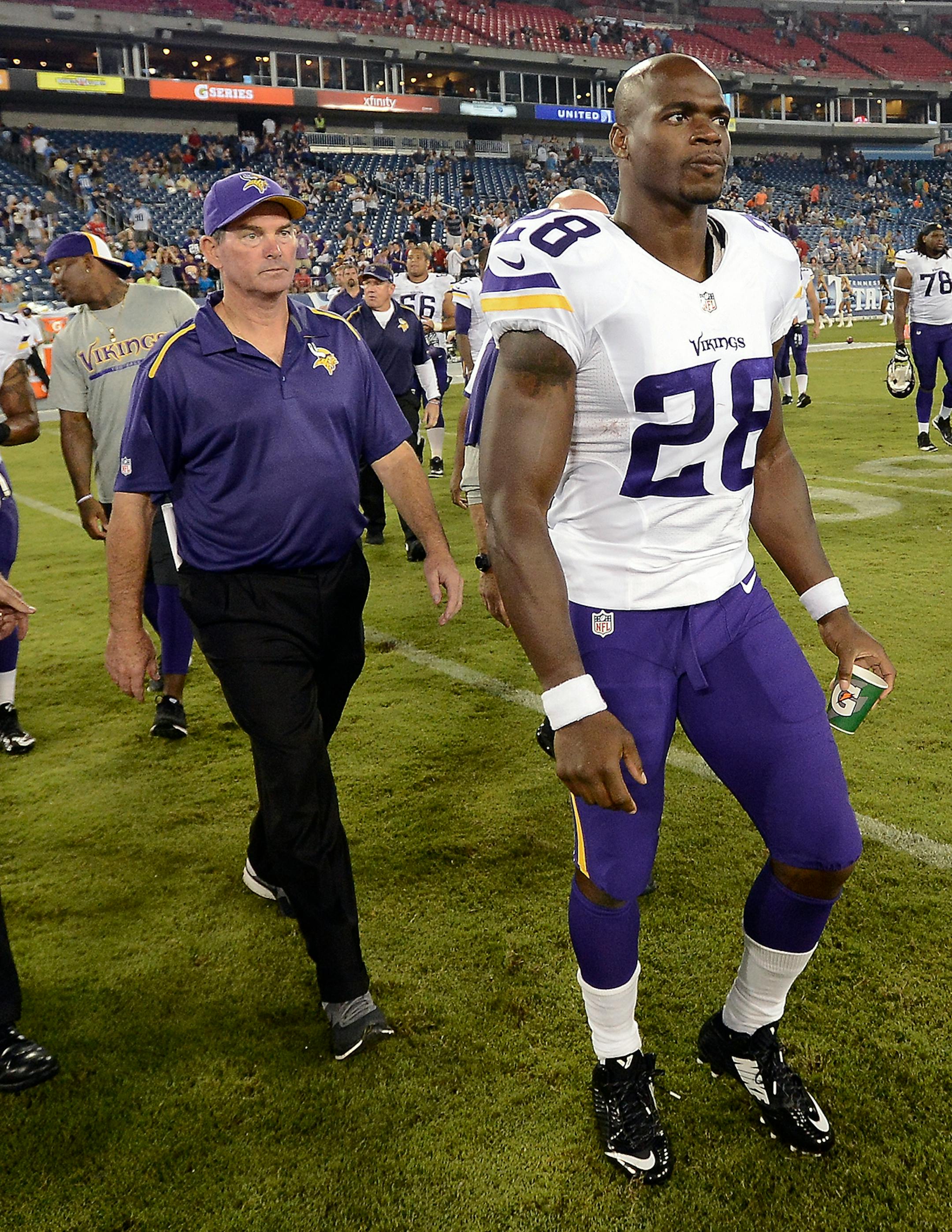 Adrian Peterson (28) and head coach Mike Zimmer, left, walk onto the field after beating the Tennessee Titans 19-3 in a preseason NFL football game Thursday, Aug. 28, 2014, in Nashville, Tenn.