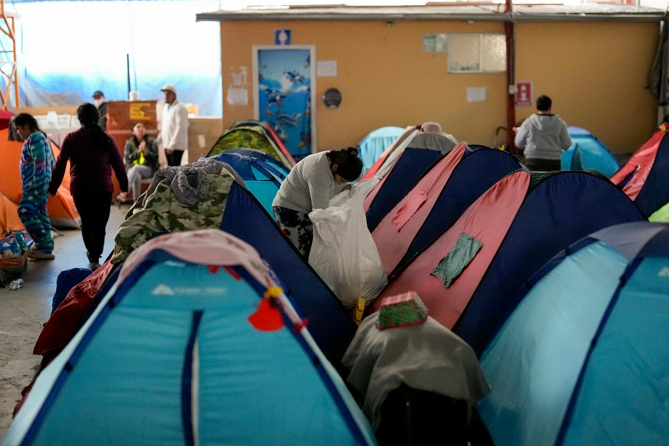 Asylum seekers wait for appointments through the CBP One app to apply for asylum in the United States in a shelter for migrants, Saturday, Feb. 3, 2024, in Tijuana, Mexico.