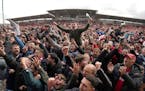 Wrexham fans invade the pitch celebrating promotion to League One after the final whistle of a League Two soccer match, Saturday, April 13, 2024, in W