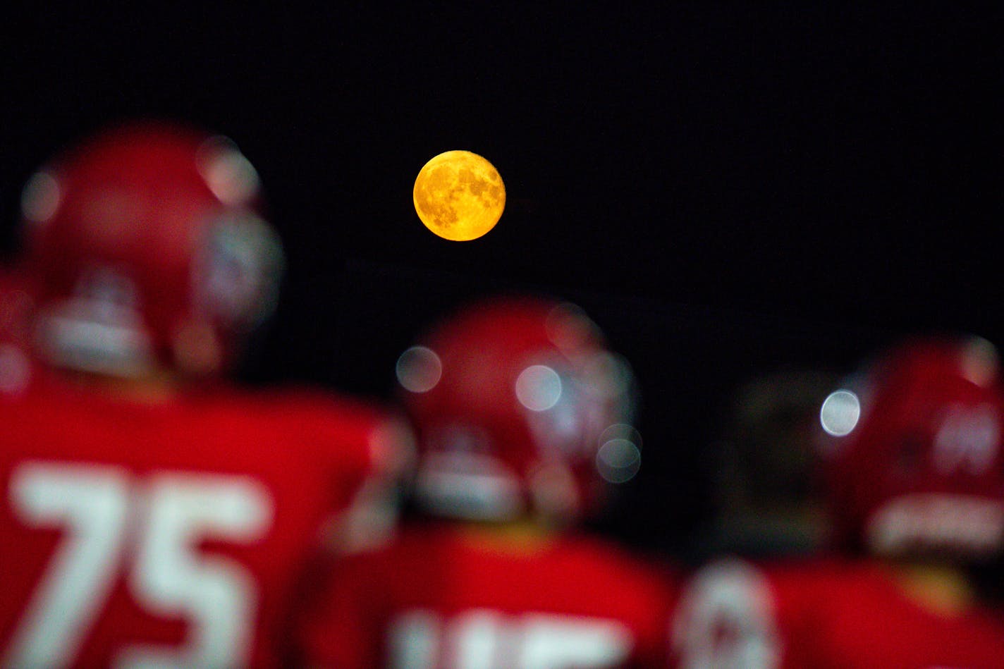 The moon rises over the Elk River team in the second half of the opening night game between Elk River High School and Chanhassen High School Thursday, Aug. 31, 2023 at Elk River High School.