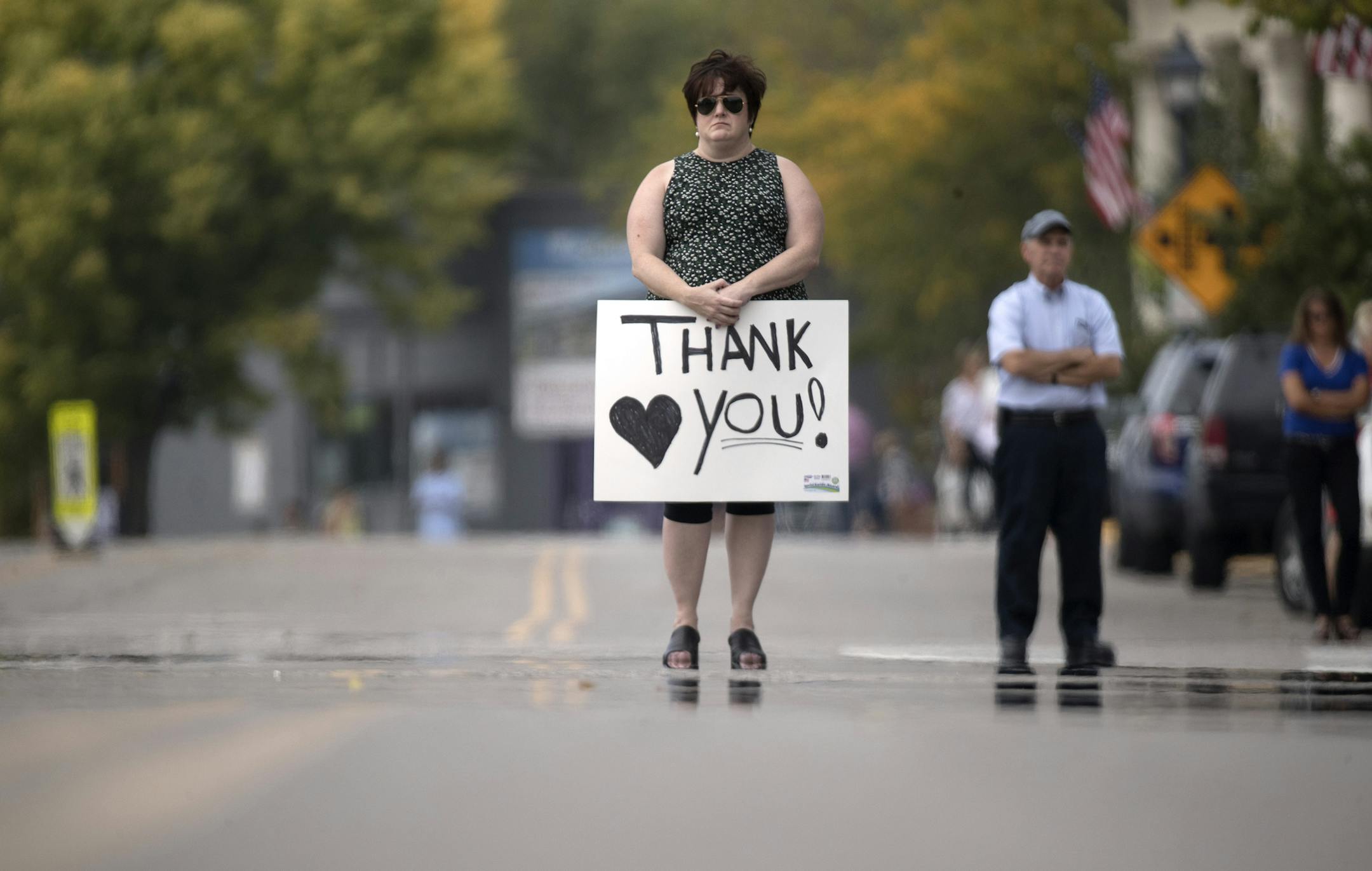 Sheila Wilson of Wayzata holding a "thank you " sign stood on Lake Street. Wilson graduated from high school with Shawn Mathewís wife of Wayzata Police Officer Bill Mathews. The funeral processions for Wayzata Police Officer Bill Mathews passed by Lake Minnetonka to Summit Park Cemetery were he will be buried Thursday September 14,2017 in Wayzata, MN. ] JERRY HOLT ï jerry.holt@startribune.com