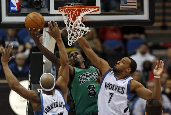 At the Target Center in a game between the Wolves and the Celtics, Dante Cunningham(33) and Derrick Williams(7) defended against Jeff Green(8).