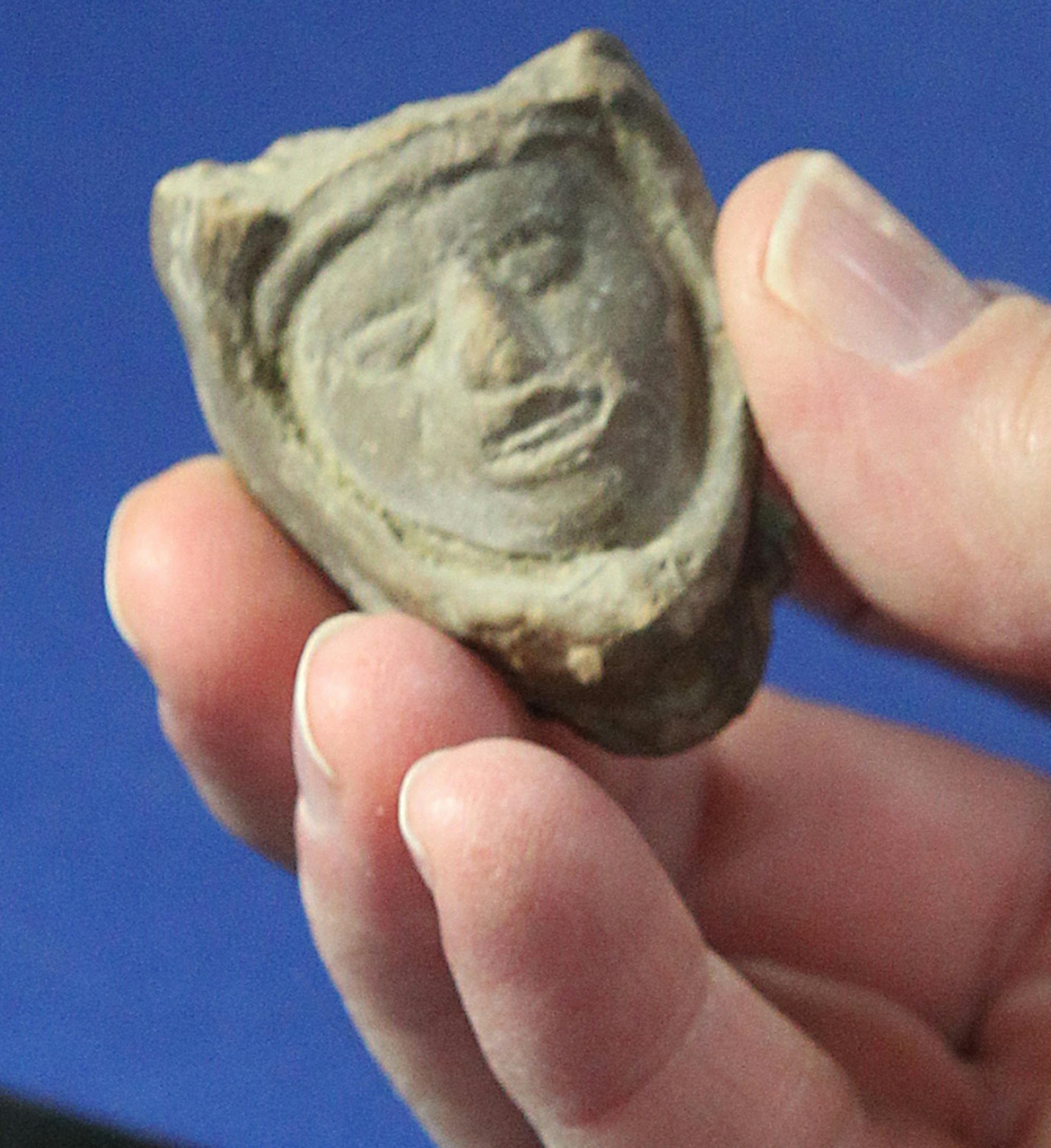 Appraiser Bruce M. Shackelford holds a pre-columbian fertility figure owned by Jennifer and Craig Webb, Akron Beacon Journal Metro editor, during the Antiques Roadshow 2015 summer tour in Cleveland, Ohio, on Saturday, July 11, 2015. (Mike Cardew/Akron Beacon Journal/TNS)