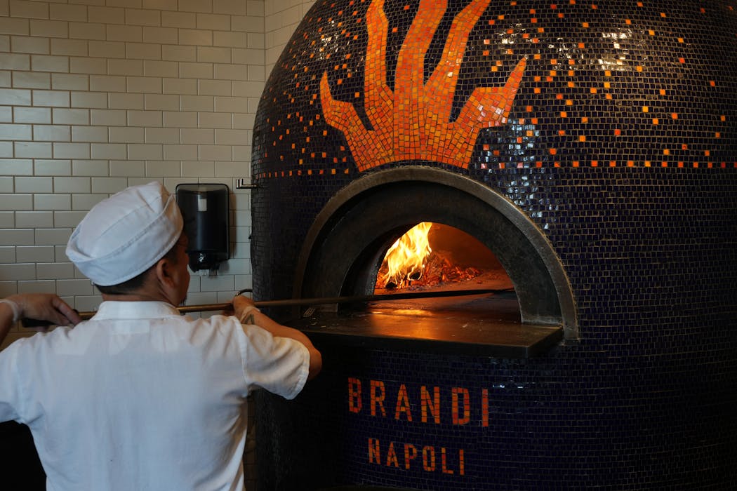Jorge Urgiles turns pizza in a wood fire oven Friday, Aug. 4, 2023 at Punch Pizza on Grand Avenue in St. Paul, Minn. 