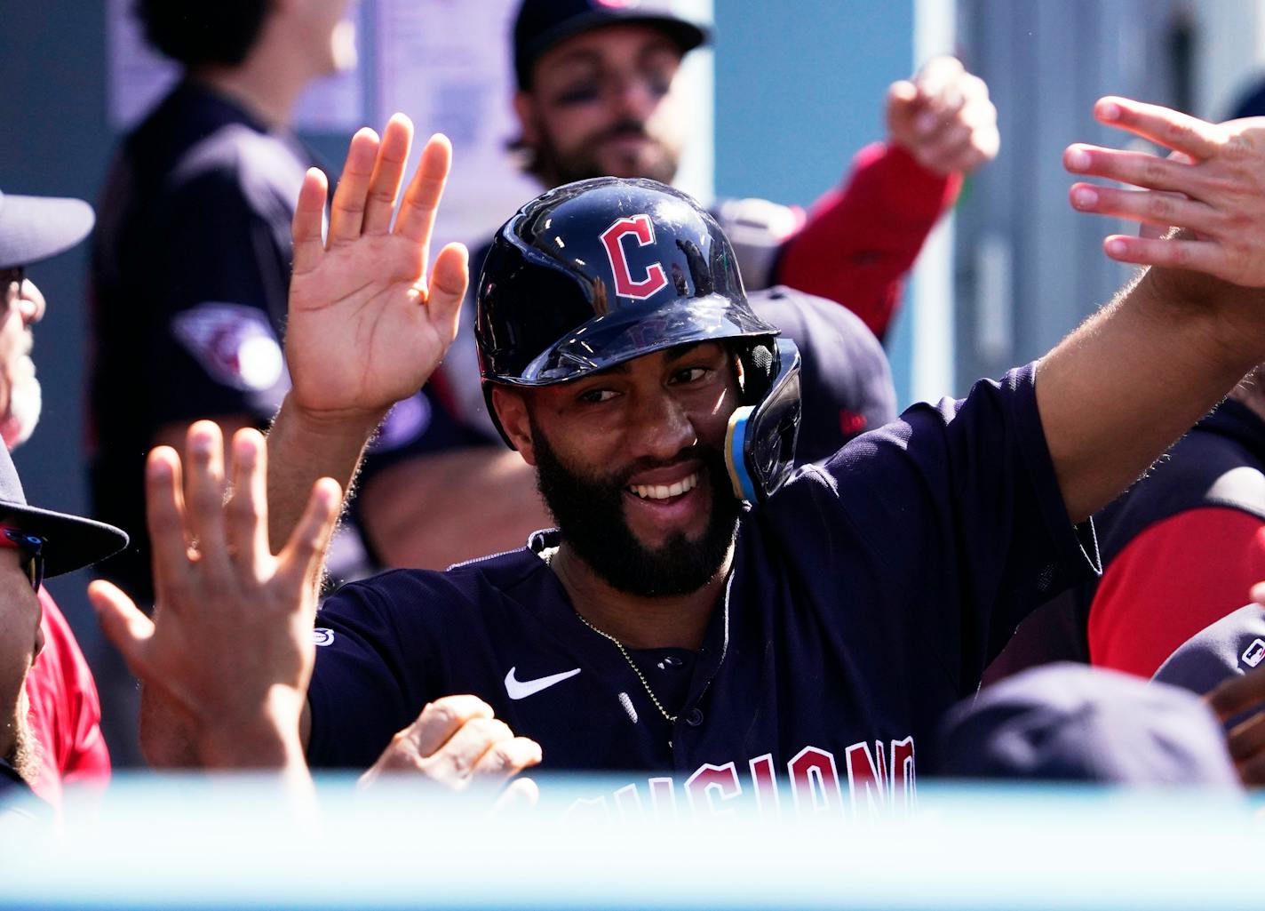 Cleveland Guardians' Amed Rosario is congratulated by teammates in the dugout after scoring on an error by Los Angeles Dodgers second baseman Max Muncy while fielding a ball hit by Oscar Mercado during the first inning of a baseball game Saturday, June 18, 2022, in Los Angeles. (AP Photo/Mark J. Terrill)