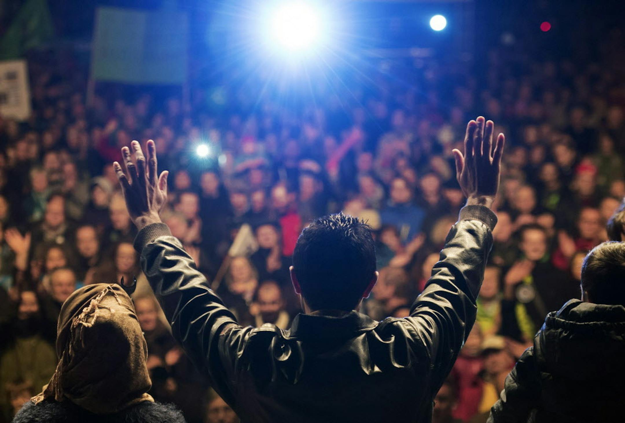 A Syrian family thank the German people and the German Chancellor Angela Merkel in front of thousands of people during a rally of the Alliance for democracy, diversity and human solidarity in Erfurt, central Germany, Monday, Nov. 9, 2015. They demand a better integration of migrants in Germany and condemn any kind of violence. (AP Photo/Jens Meyer)