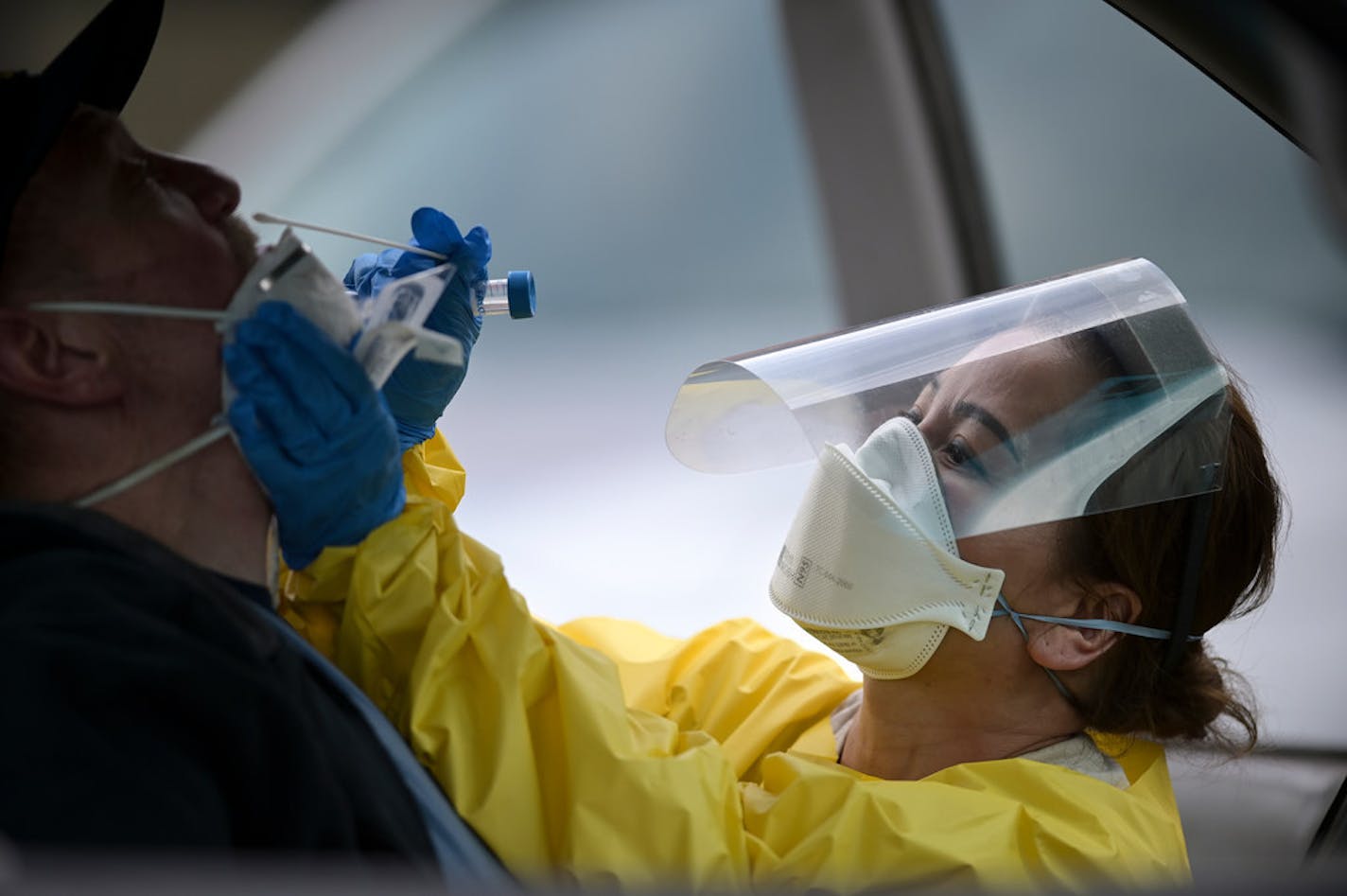 Elizabeth Santoro, a medic with the Minnesota Air National Guard 133rd Medical Group, administered a free COVID-19 test to Thomas Harmon, 61, of Robbinsdale in May.