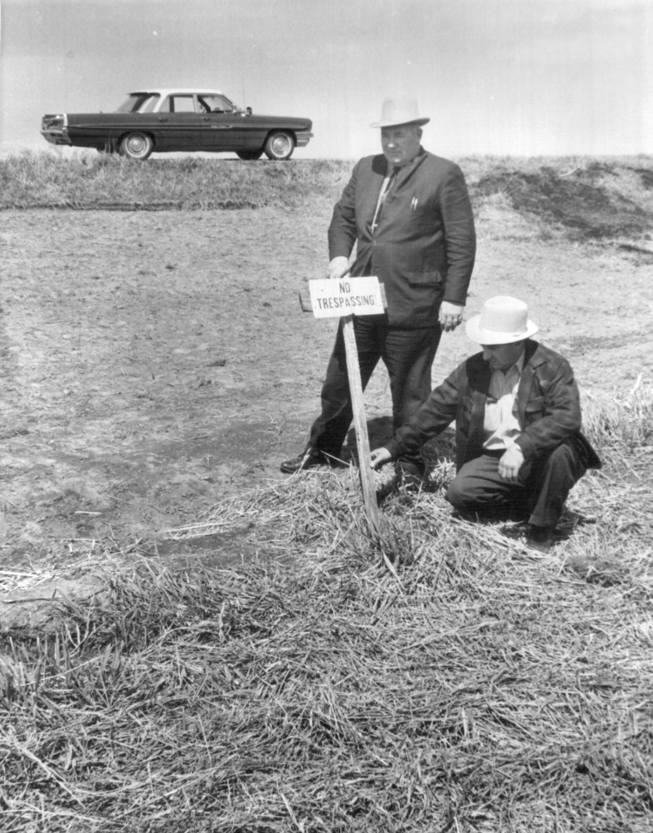 May 2, 1963 Sherburne County deputy George moos show where he found gun Sheriff Chester Goenner is standing; gun was found at foot of stake St. paul attorney Thompson testified for more than three hours Wednesday before the Ramsey County Grand Jury. Meanwhile, police investigators were analyzing the Luger pistol used to beat his wife to death. The gun was found by police Tuesday afternoon in a swampy area of Sherburne County on information supplied by Sheldon Morris, one of three men charged wit