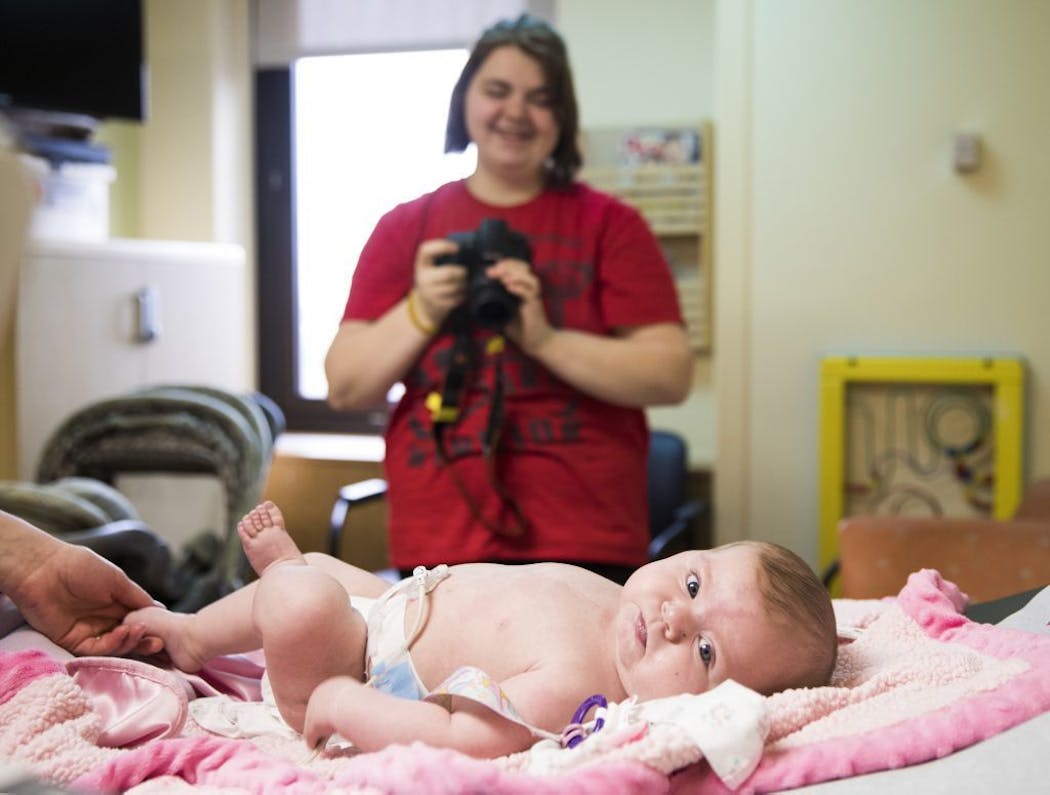 Chelsea Ohlquist takes photos of her infant daughter Corah after an electrocardiogram.