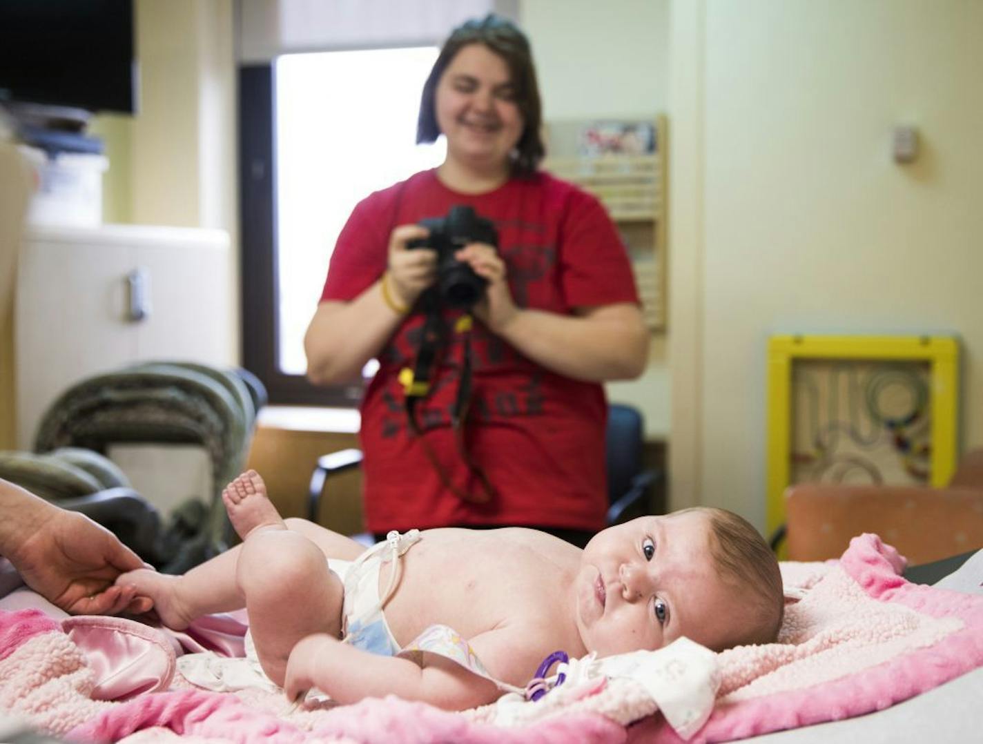 Chelsea Ohlquist takes photos of her infant daughter Corah after an electrocardiogram.