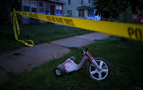 A child’s tricycle inside the police tape at the scene of a shooting in north Minneapolis in August 2020, in which multiple people were reported sho