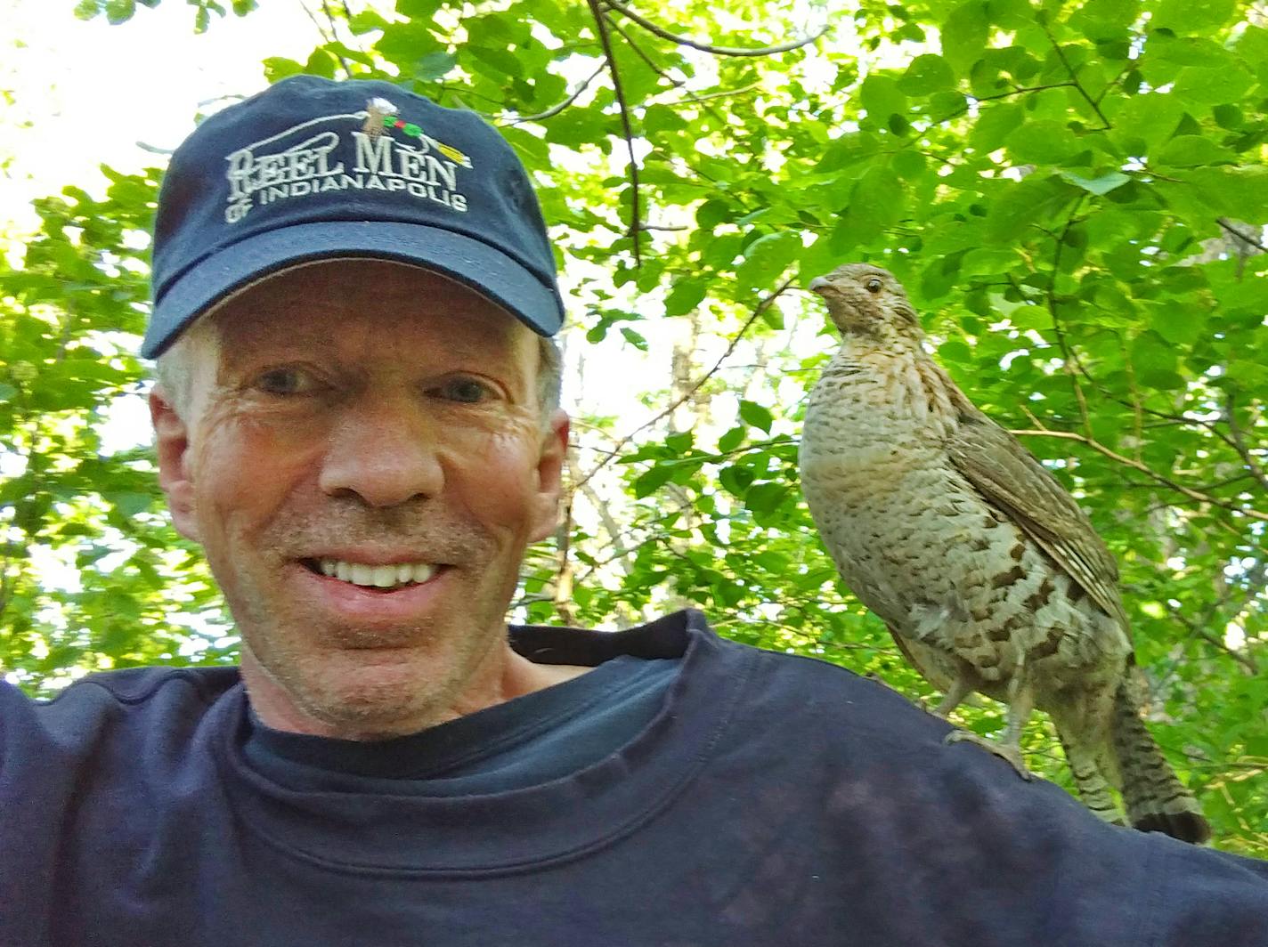 Brainerd wildlife photographer Bill Marchel with "Doofus,'' a wild ruffed grouse that has befriended Marchel during multiple encounters in the woods.