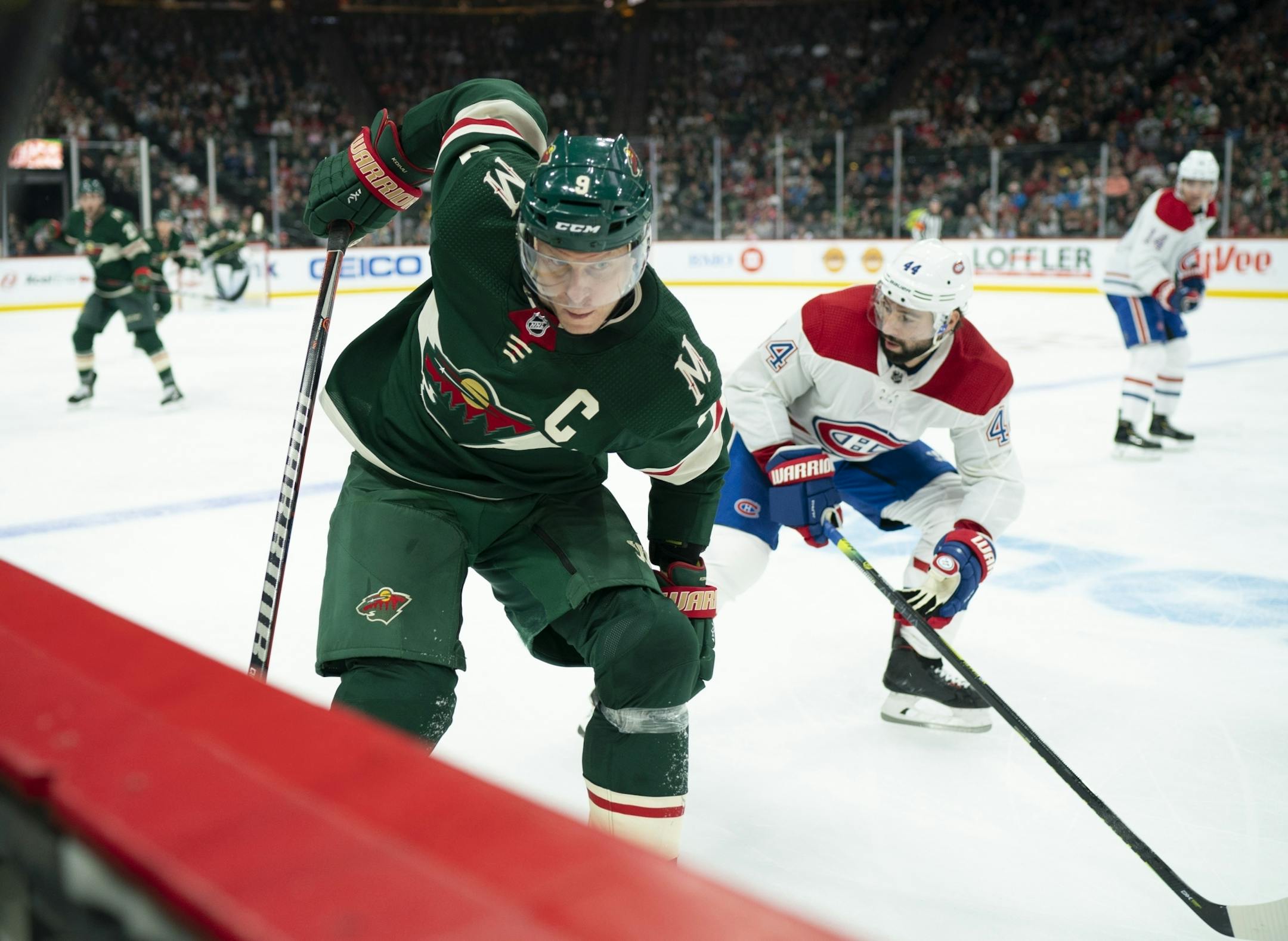 Minnesota Wild center Mikko Koivu (9) brought the puck up ice along the boards while triled by Montreal Canadiens center Nate Thompson (44) in the third period.