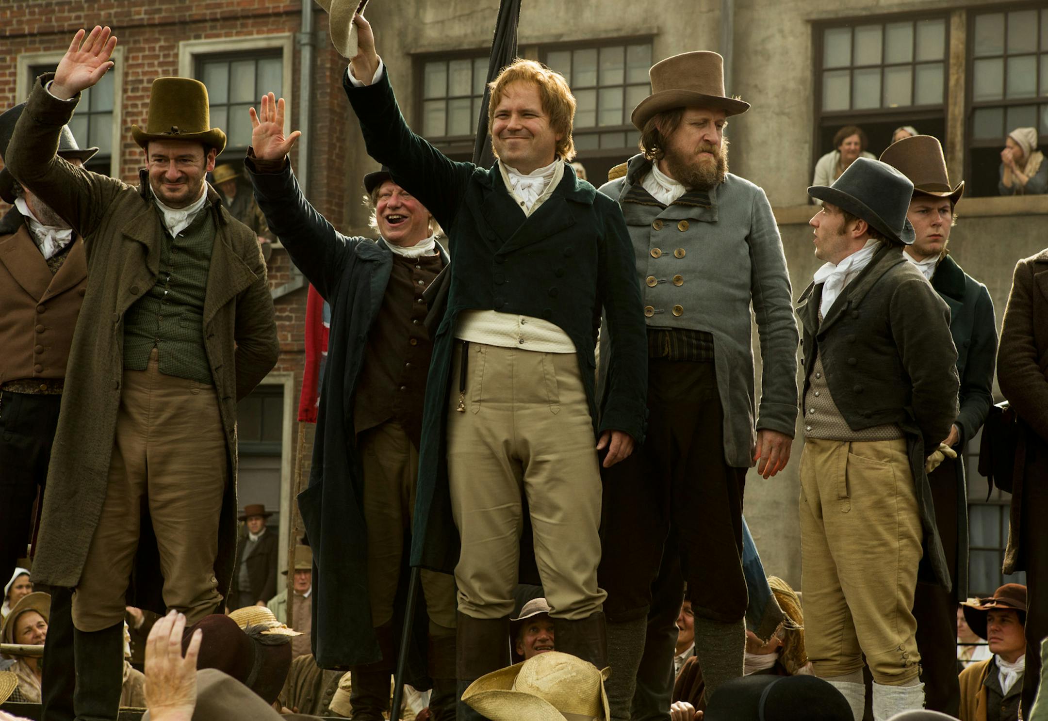 PETERLOO featuring John-Paul Hurley as John Thacker Saxton, Ian Mercer as Dr. Joseph Healey, Rory Kinnear as Henry Hunt, and Neil Bell as Samuel Bamford courtesy of Amazon Studios.