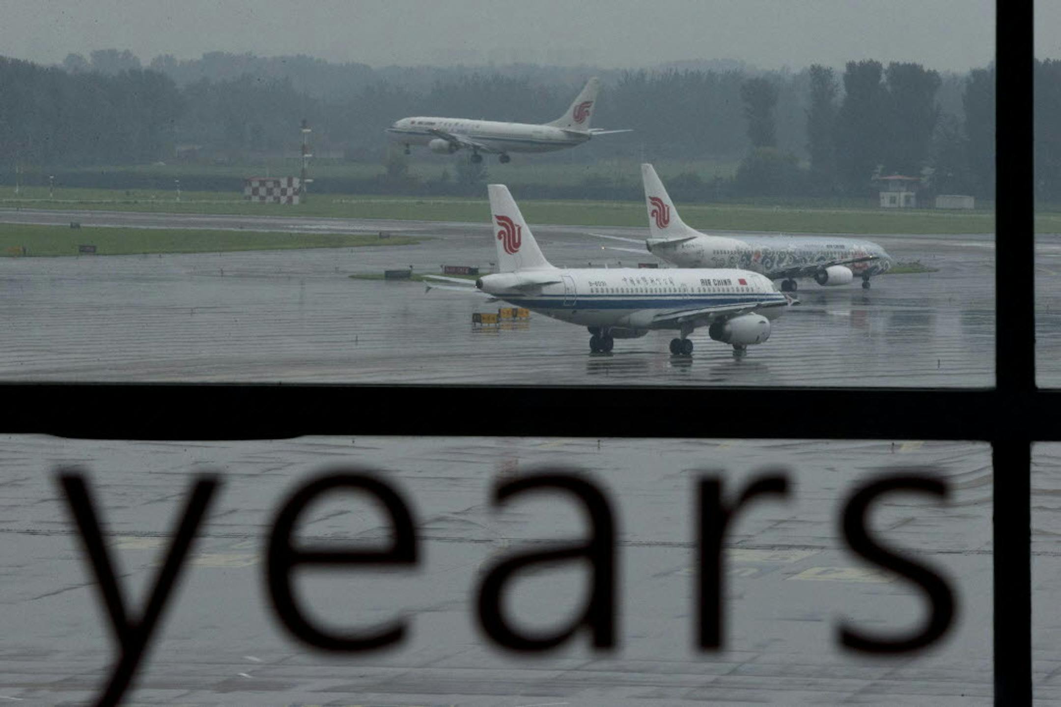 Aug. 1, 2013: An Air China passenger plane lands while two other Air China planes wait to take off at Terminal 3 of the Beijing International Airport in Beijing, China.