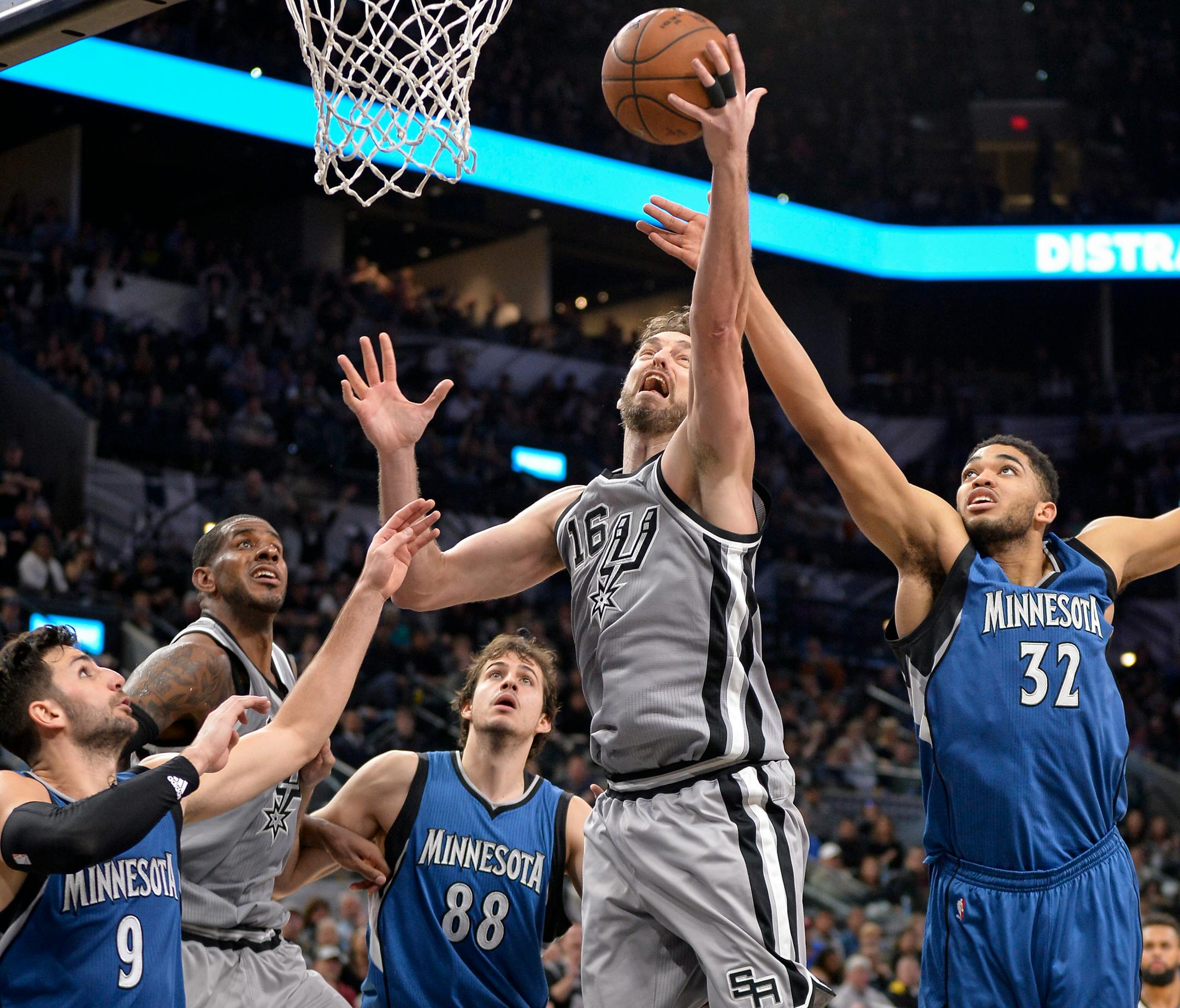 Spurs center Pau Gasol (16) and Timberwolves center Karl Anthony-Towns (32) reach for a rebound as Minnesota's Ricky Rubio (9) and Nemanja Bjelica (88) and San Antonio's LaMarcus Aldridge watch during the second half Saturday night.